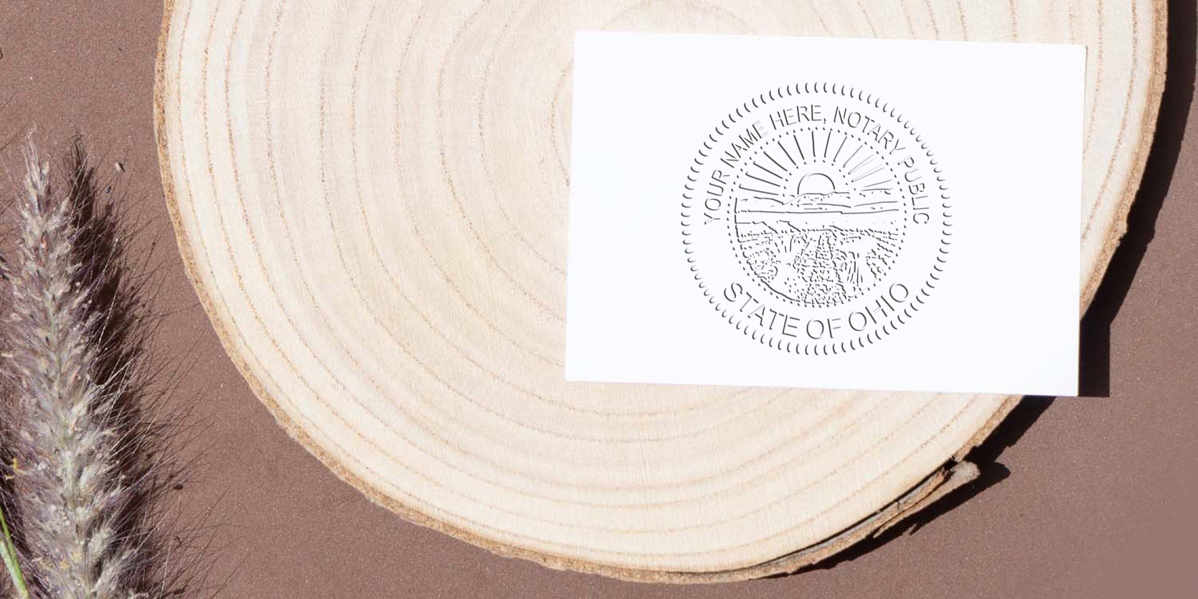 Ohio Notary Seal stamp on white card with wooden background and dried grass, highlighting Ohio Notary Seal and its features.