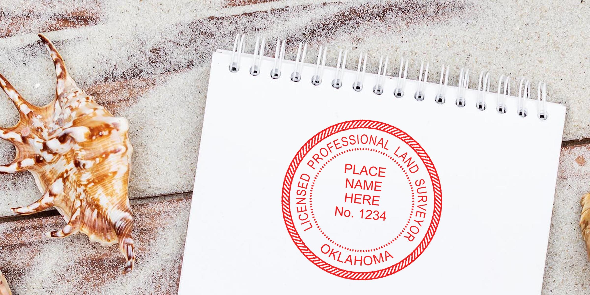 Oklahoma land surveyor seal stamped on notepad with seashells on sandy beach, displaying seal specs and licensed professional certification.