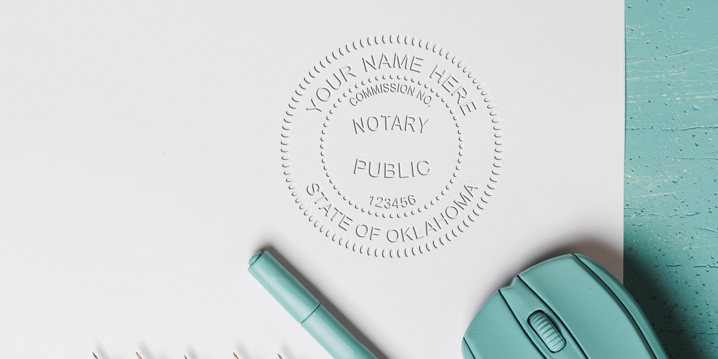 Oklahoma notary stamp embossed on white paper with teal pen and computer mouse on turquoise desk, symbolizing online notary services.
