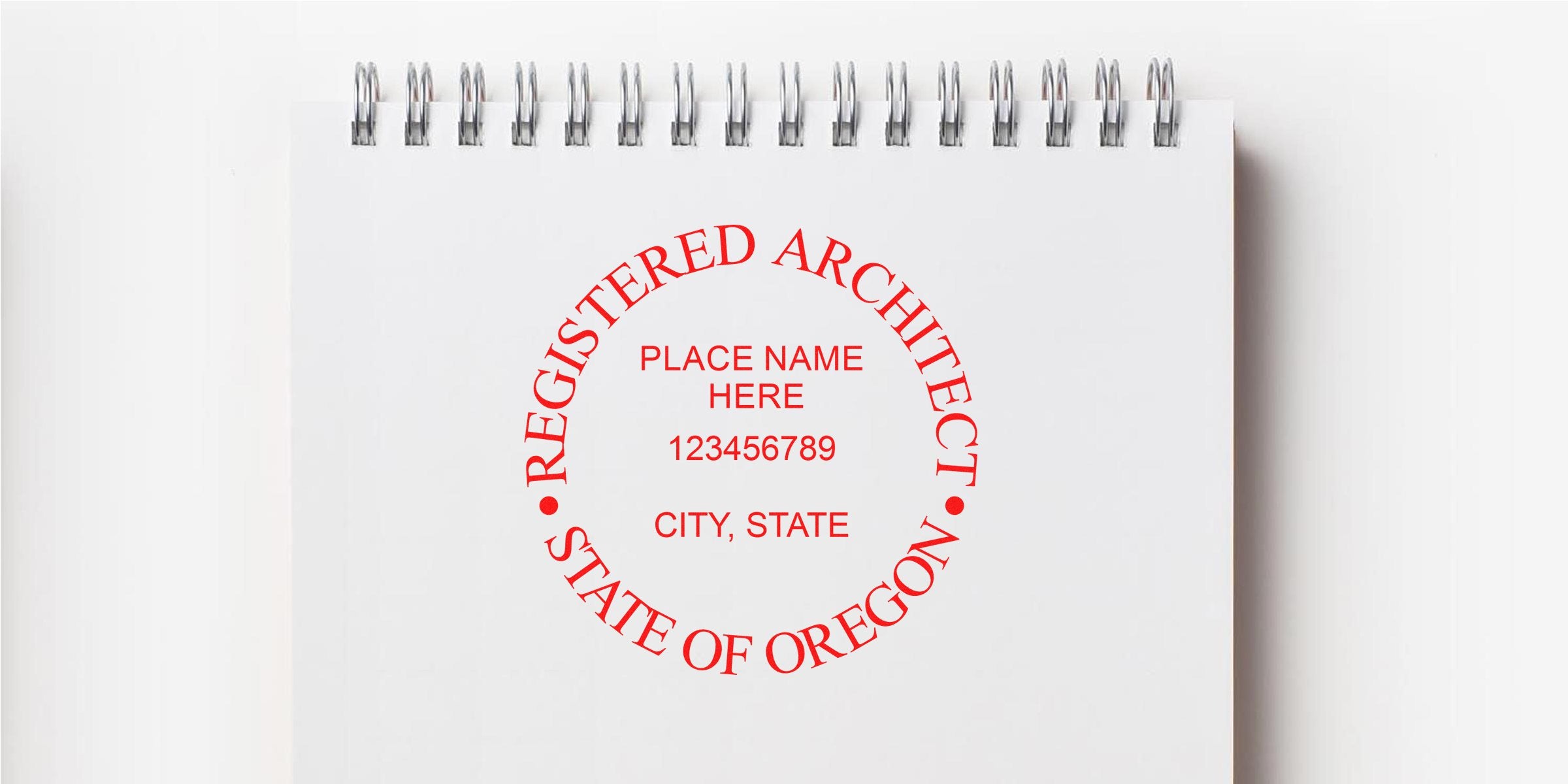 Registered architect stamp on white spiral notebook with Oregon blueprints for certification and design approval featuring architect stamps.