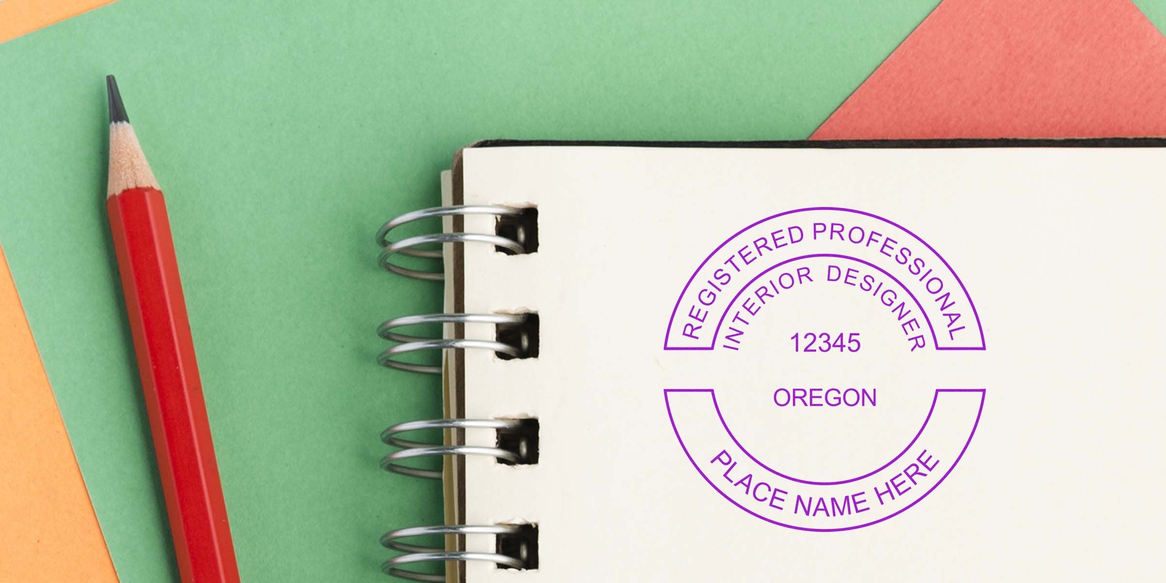 Registered interior designer stamp on notebook with red pencil on colorful background, symbolizing Oregon interior designer license and certification stamp requirements.