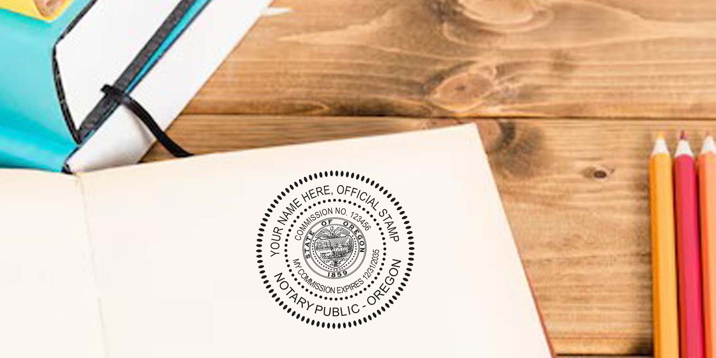 Oregon notary stamp on open notebook with colored pencils and planner on wooden desk, showing an Oregon notary public official stamp in a notary seal guide.