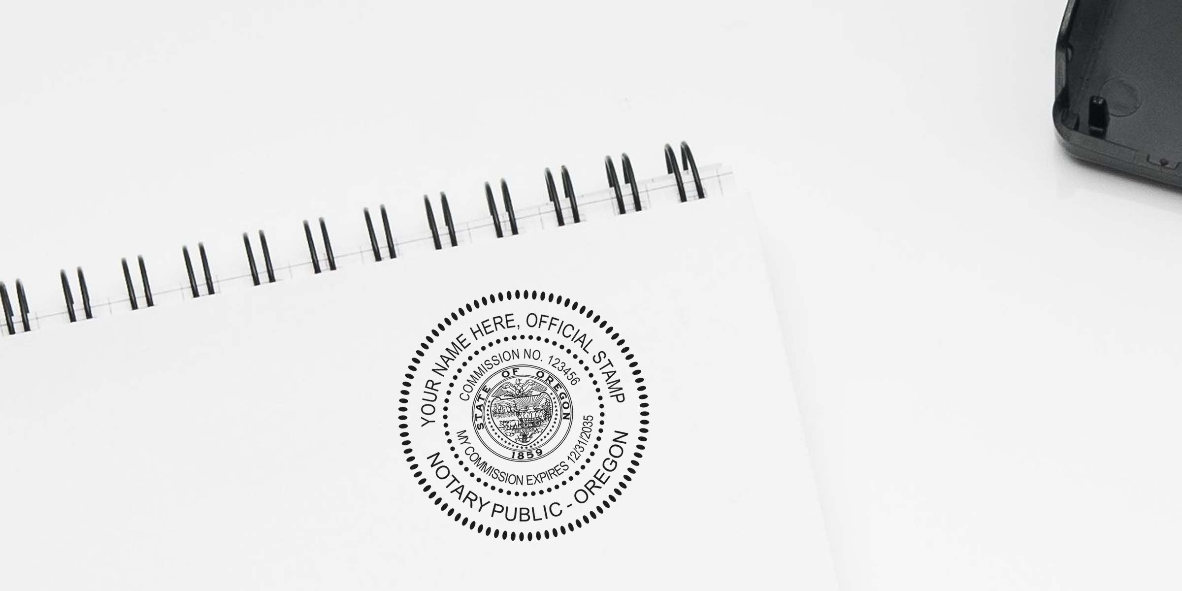 Oregon notary stamp on white spiral notebook showing public notary essentials: official seal, commission, and expiration date.