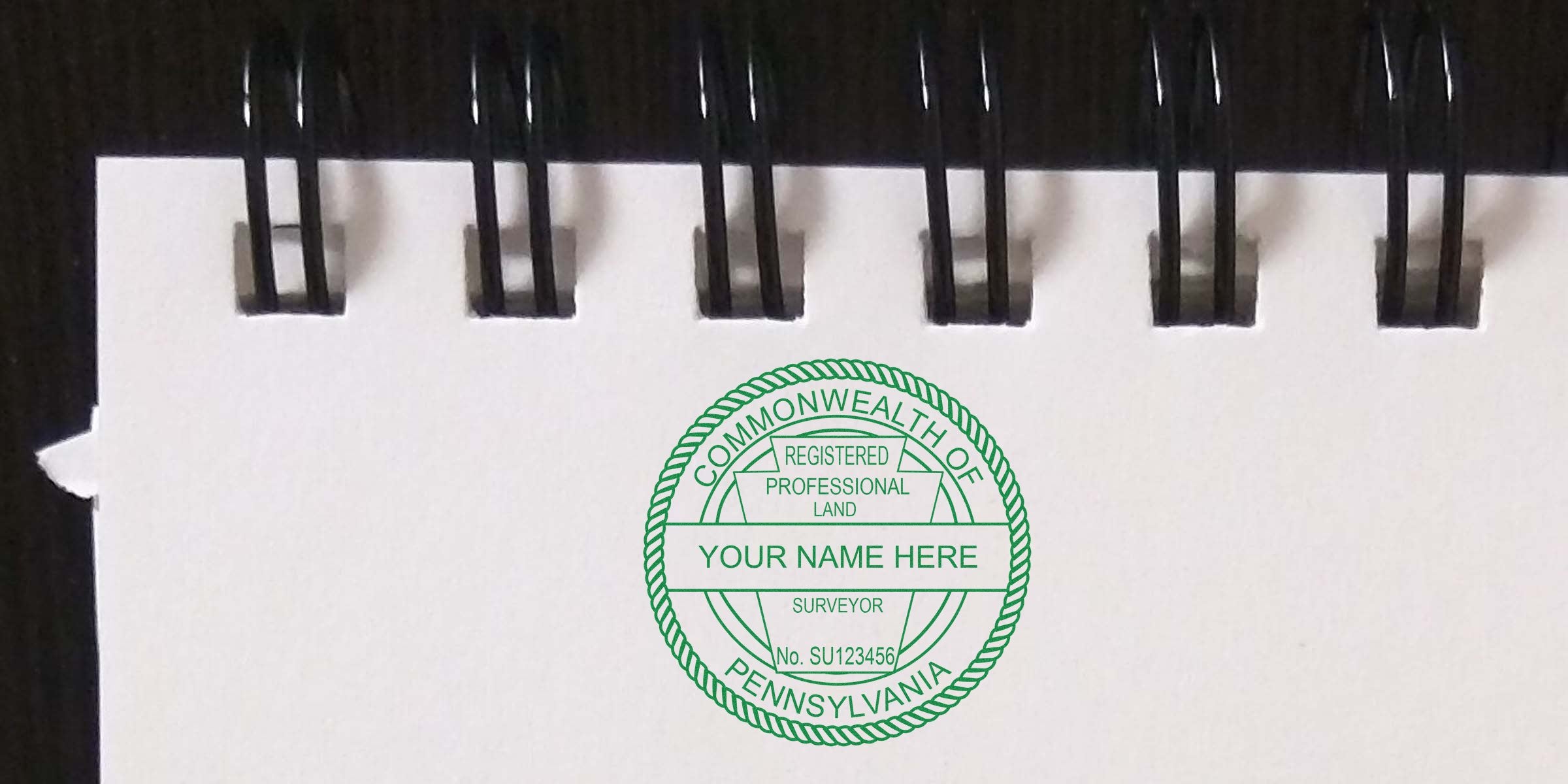 Pennsylvania professional land surveyor stamp on spiral notebook paper, highlighting PA land surveyor stamp cost and surveyor fees in Pennsylvania.