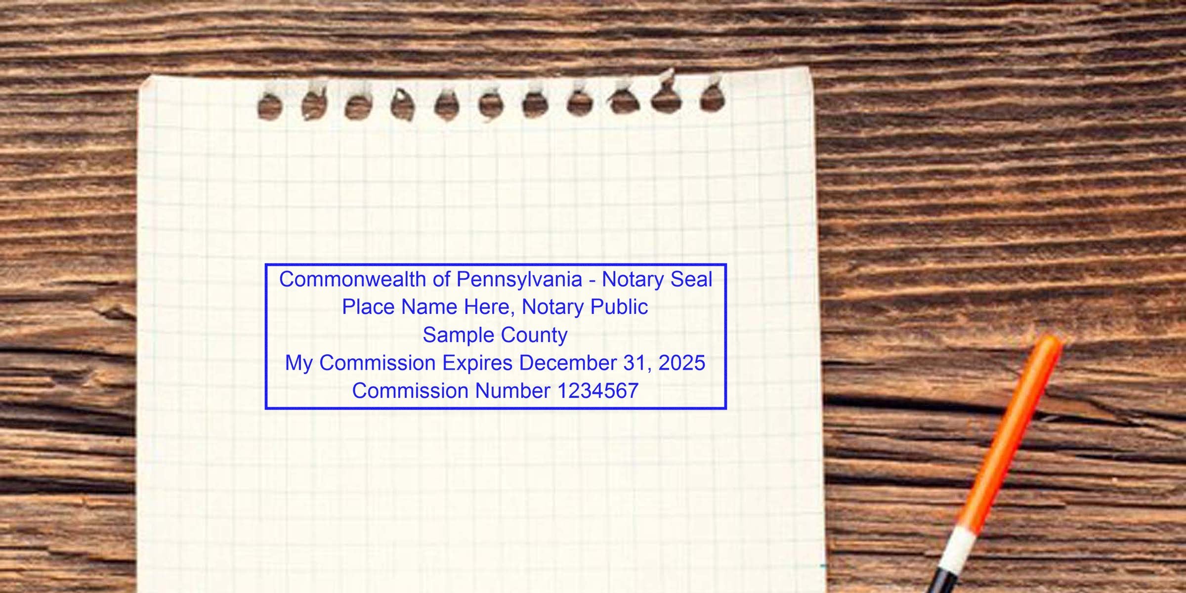 Sample Pennsylvania notary seal on grid paper with pen, showing commission expiration details, compliant with PA notary stamp law and requirements.