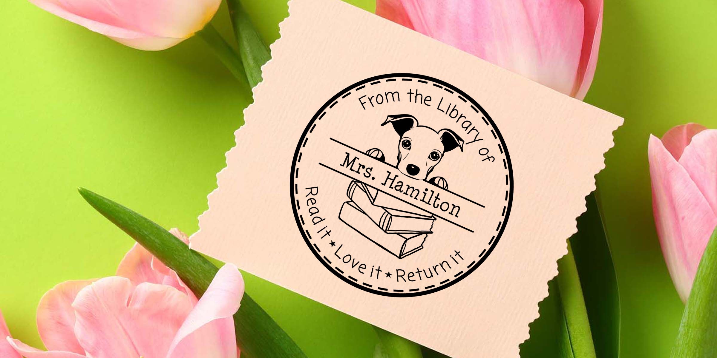 Personalized library book stamp with dog illustration and books, reading “From the Library of Mrs. Hamilton, Read it, Love it, Return it,” displayed on pastel paper with pink tulips ಹಿನ್ನೆ