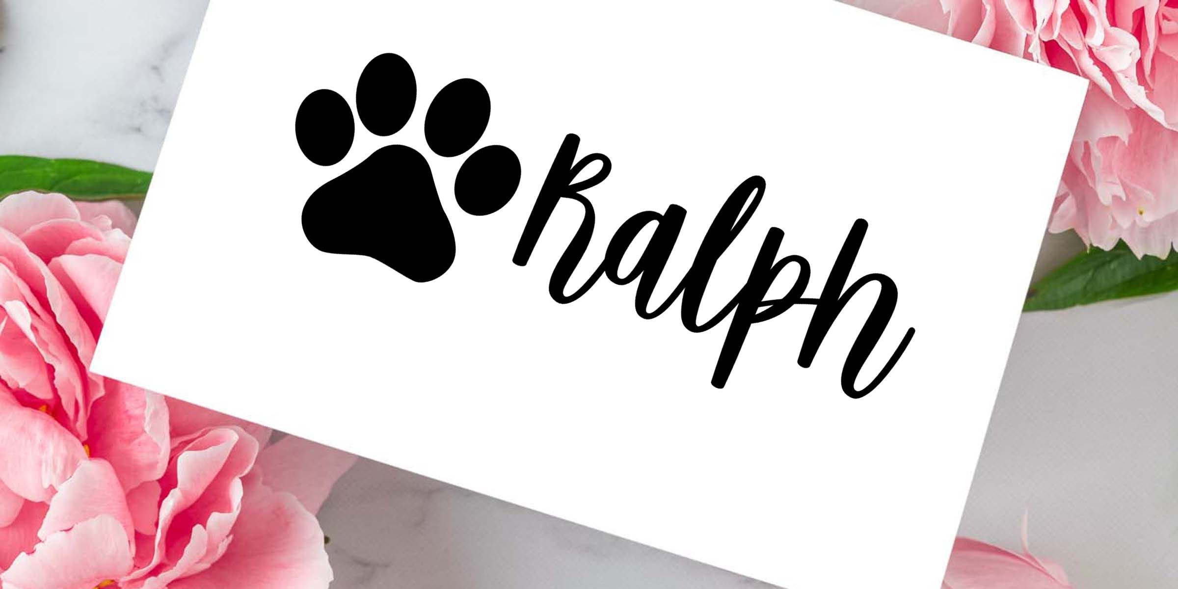 Black paw print logo with the name Ralph in elegant script on a white card surrounded by pink flowers