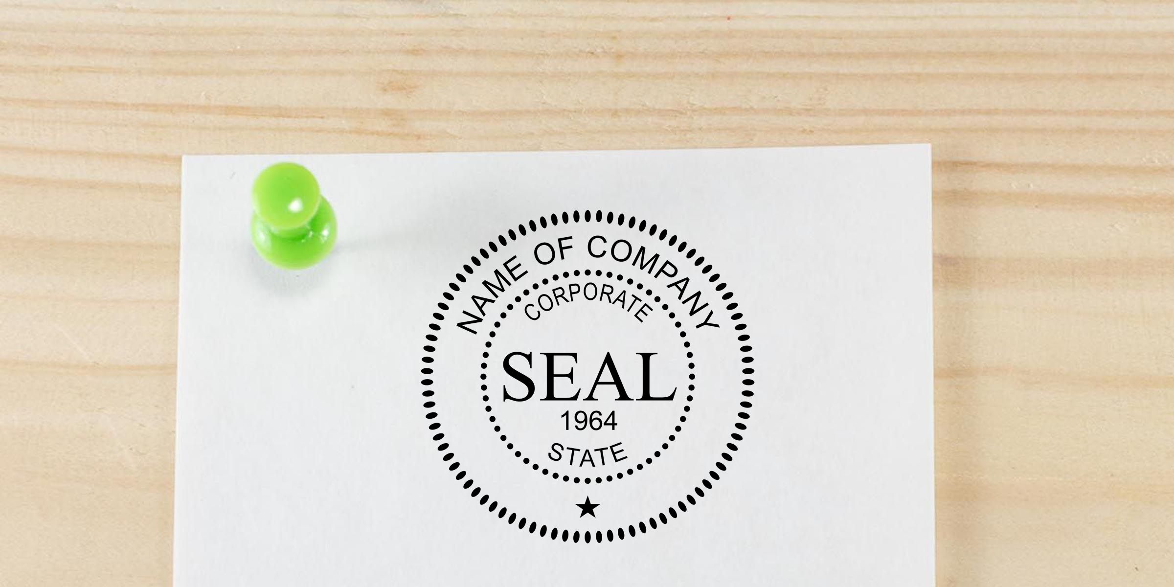 Blank corporate seal stamp on white paper pinned to a wooden surface with a green pushpin