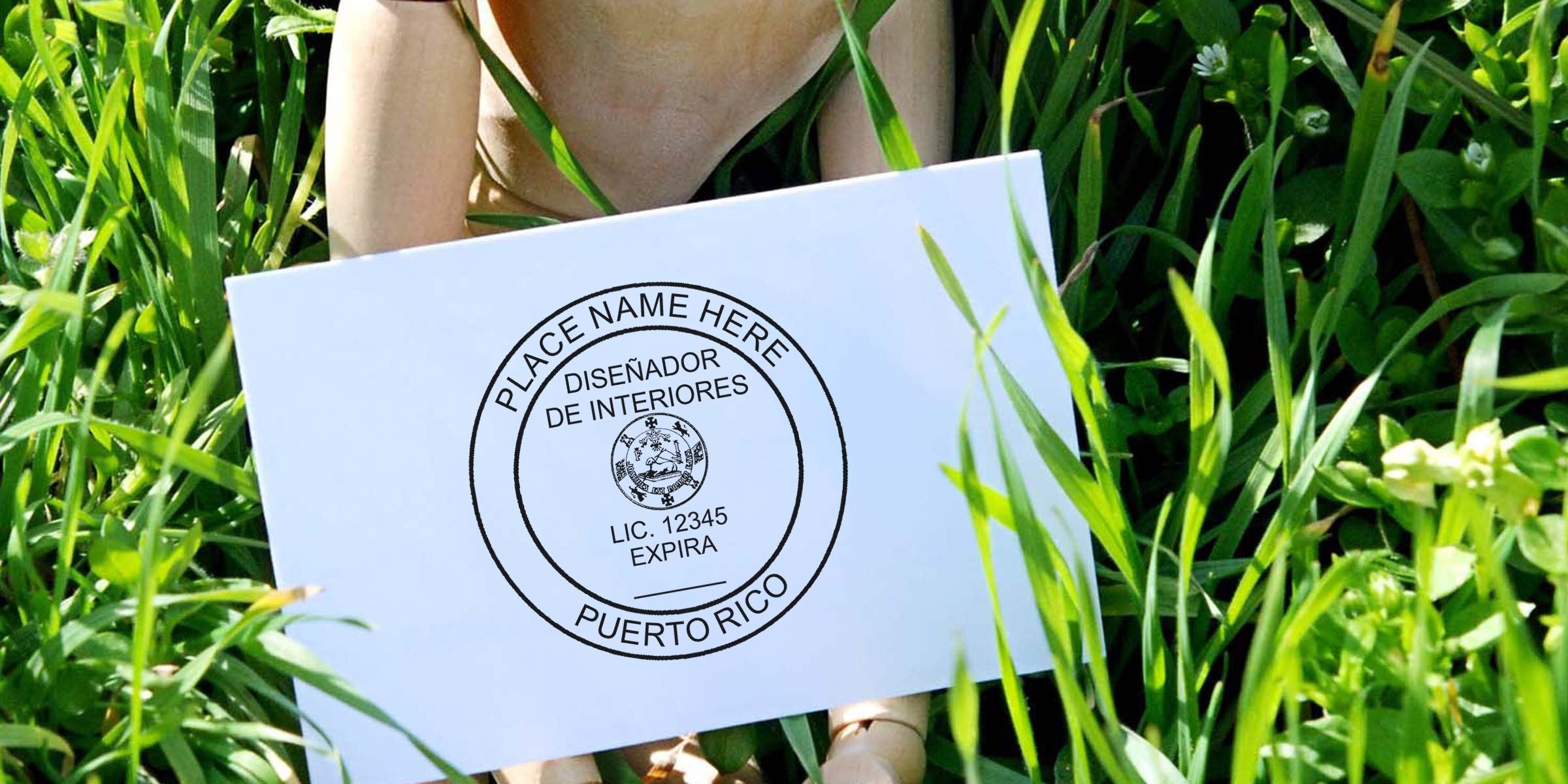 Puerto Rico interior design license stamp on white card held over green grass, showcasing stamp guidelines.