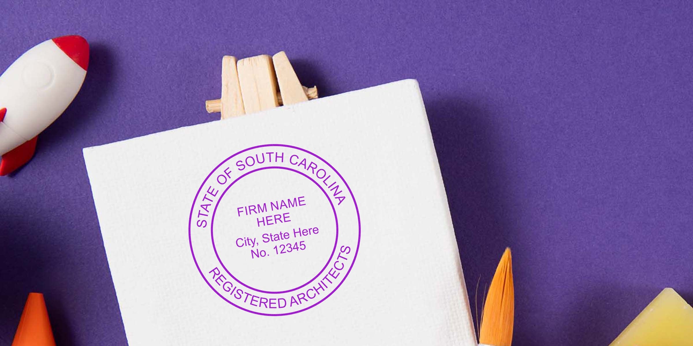 South Carolina architect stamp on white canvas with art tools and rocket toy on purple background, ideal for buying architect stamps online.