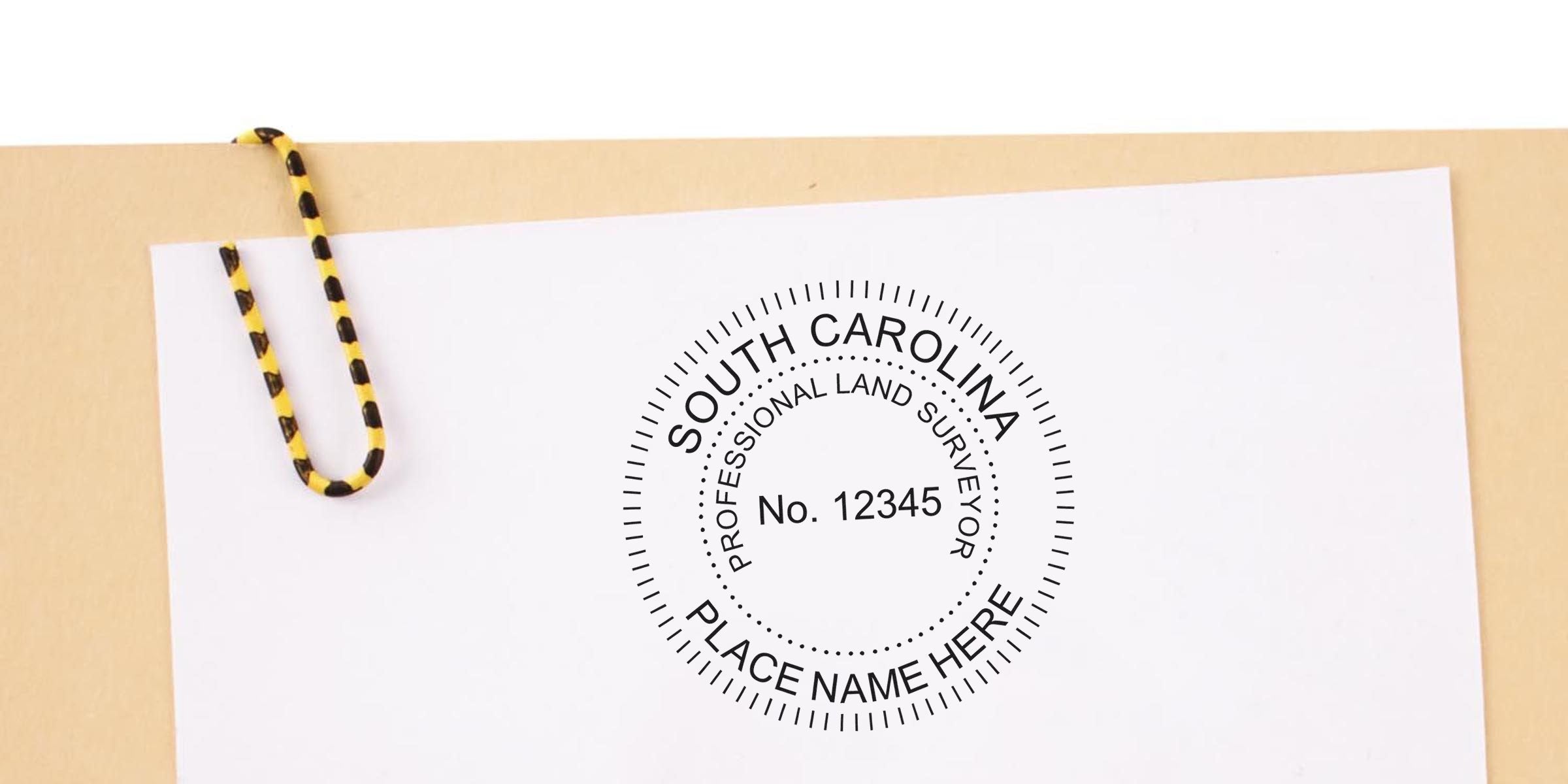 South Carolina land surveyor stamp on white paper with yellow and black paperclip, highlighting the stamp and its cost.