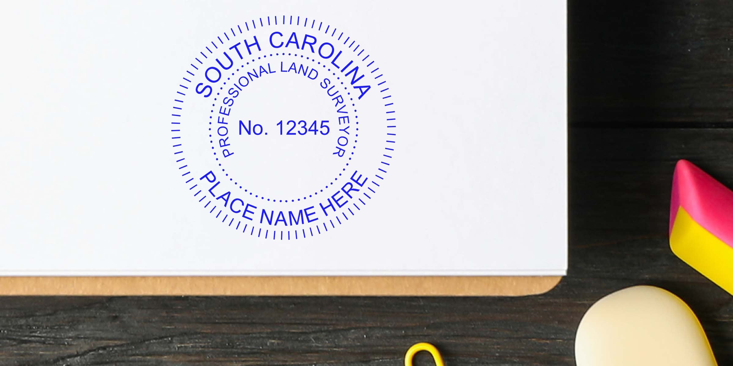 South Carolina land surveyor stamp on white paper, surrounded by office desk items, meeting all land surveyor stamp requirements.