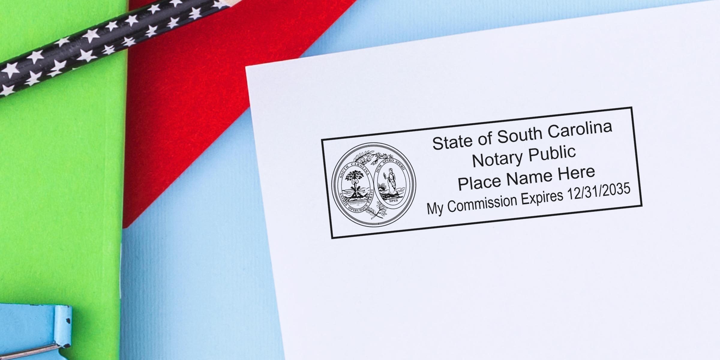 South Carolina notary stamp on white paper, colorful background, black star-patterned pencils, and a self-inking notary stamp.