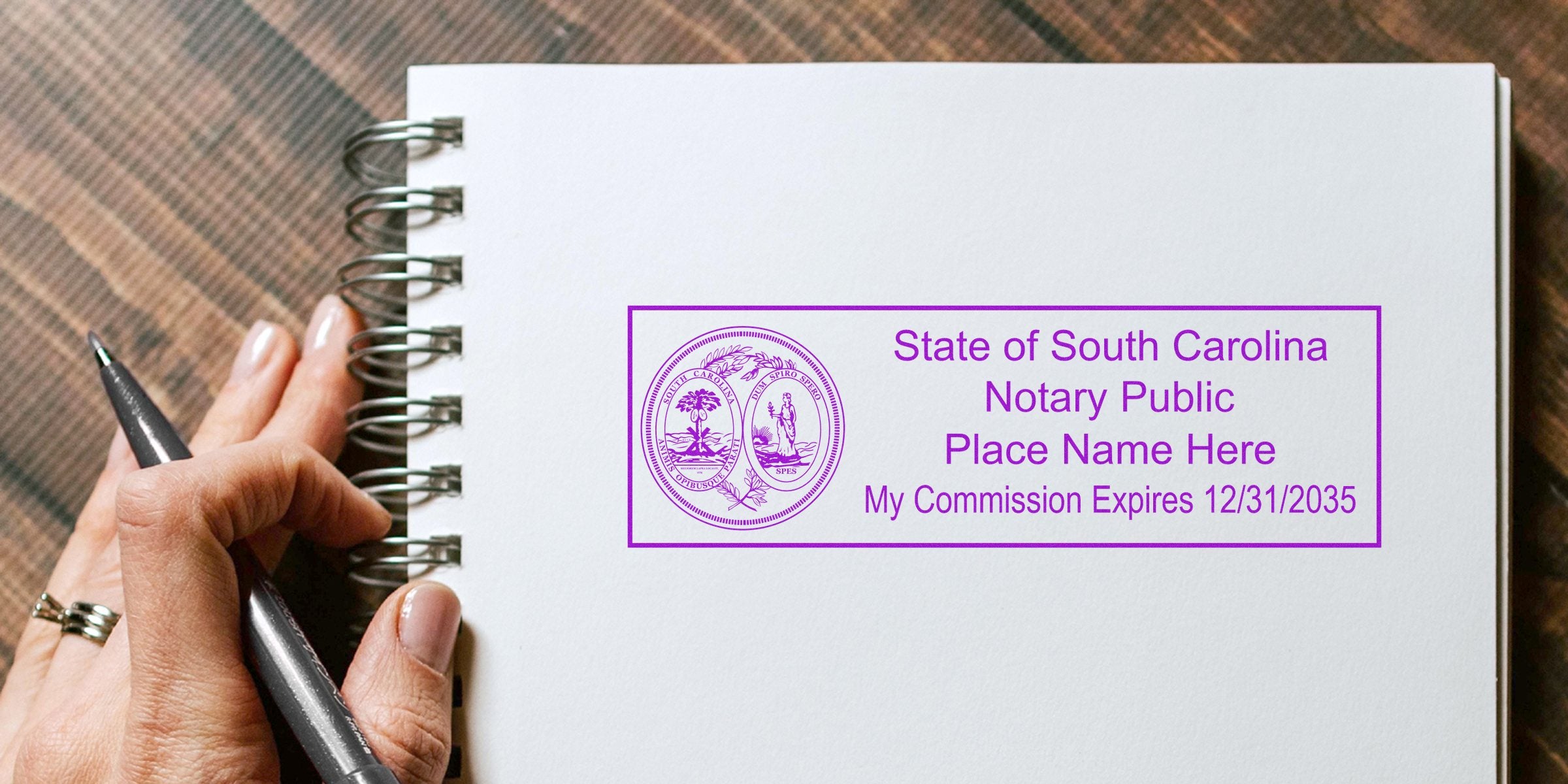 South Carolina notary stamp on notebook with hand holding pen, offering affordable and quality notary supplies.