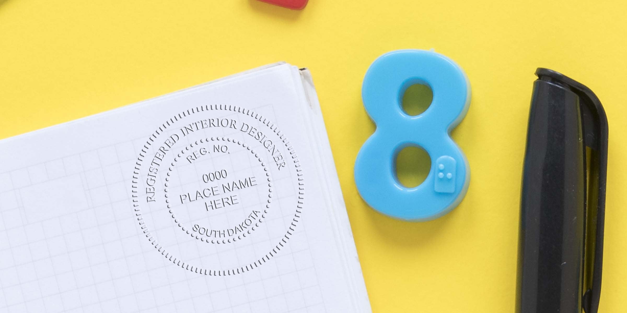 South Dakota interior designer seal with number 8 and stapler on yellow background, symbolizing interior design certification and regulations.