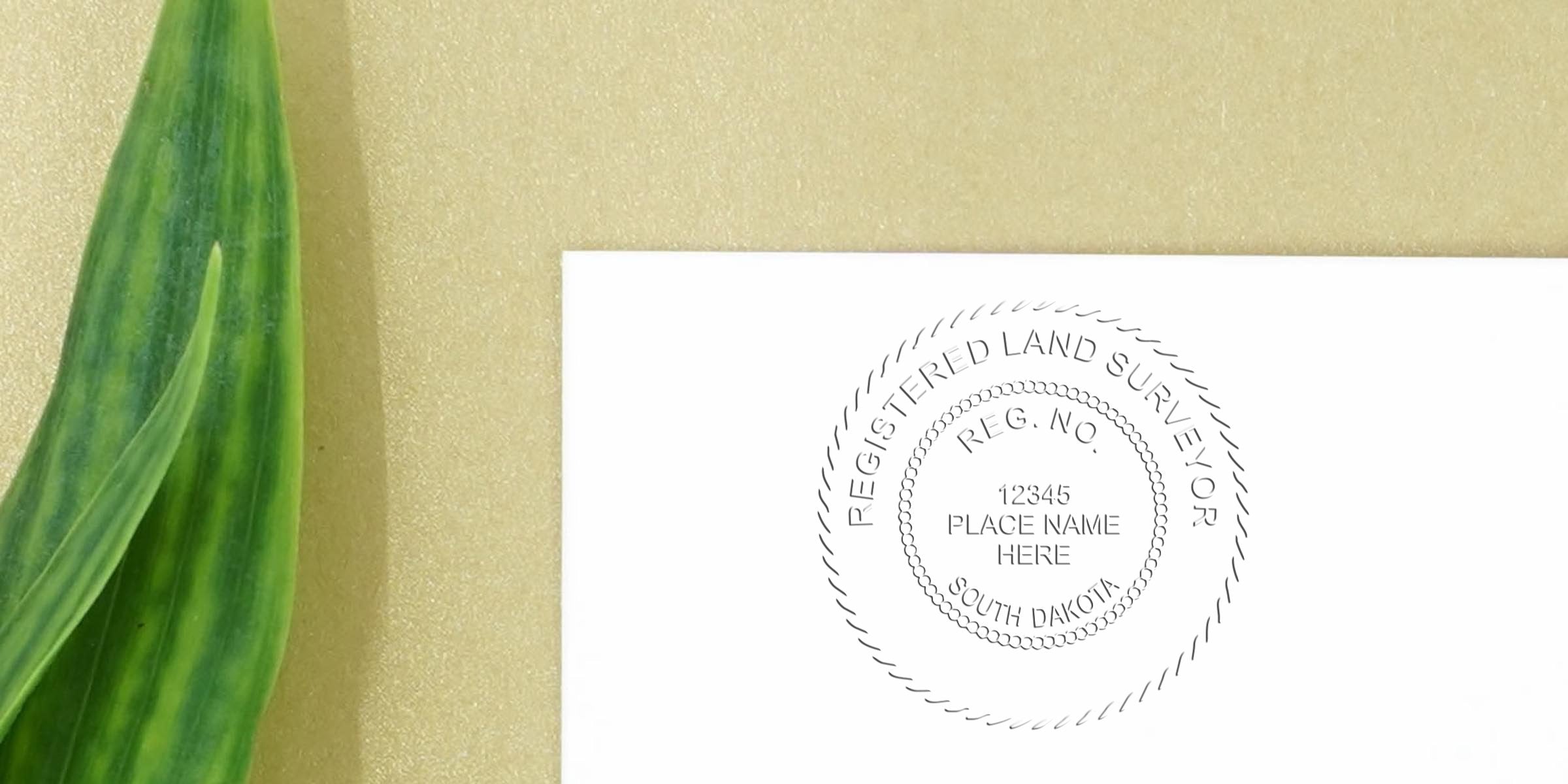 South Dakota land surveyor stamp on white paper with a green leaf, symbolizing professional land survey services and guidance.
