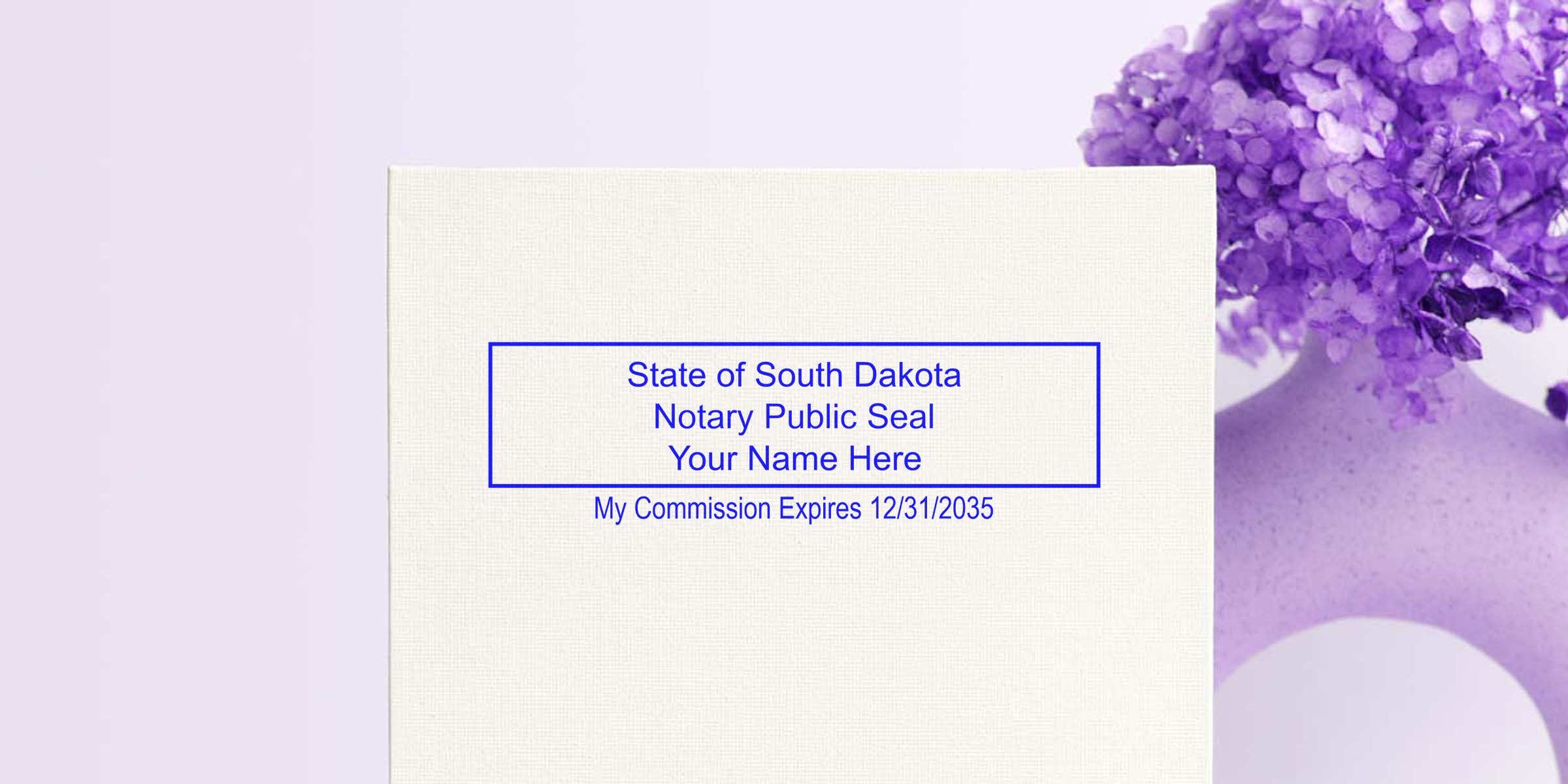 South Dakota notary stamp with commission expiry on textured paper, beside purple flowers in a vase, showing official notary supplies.