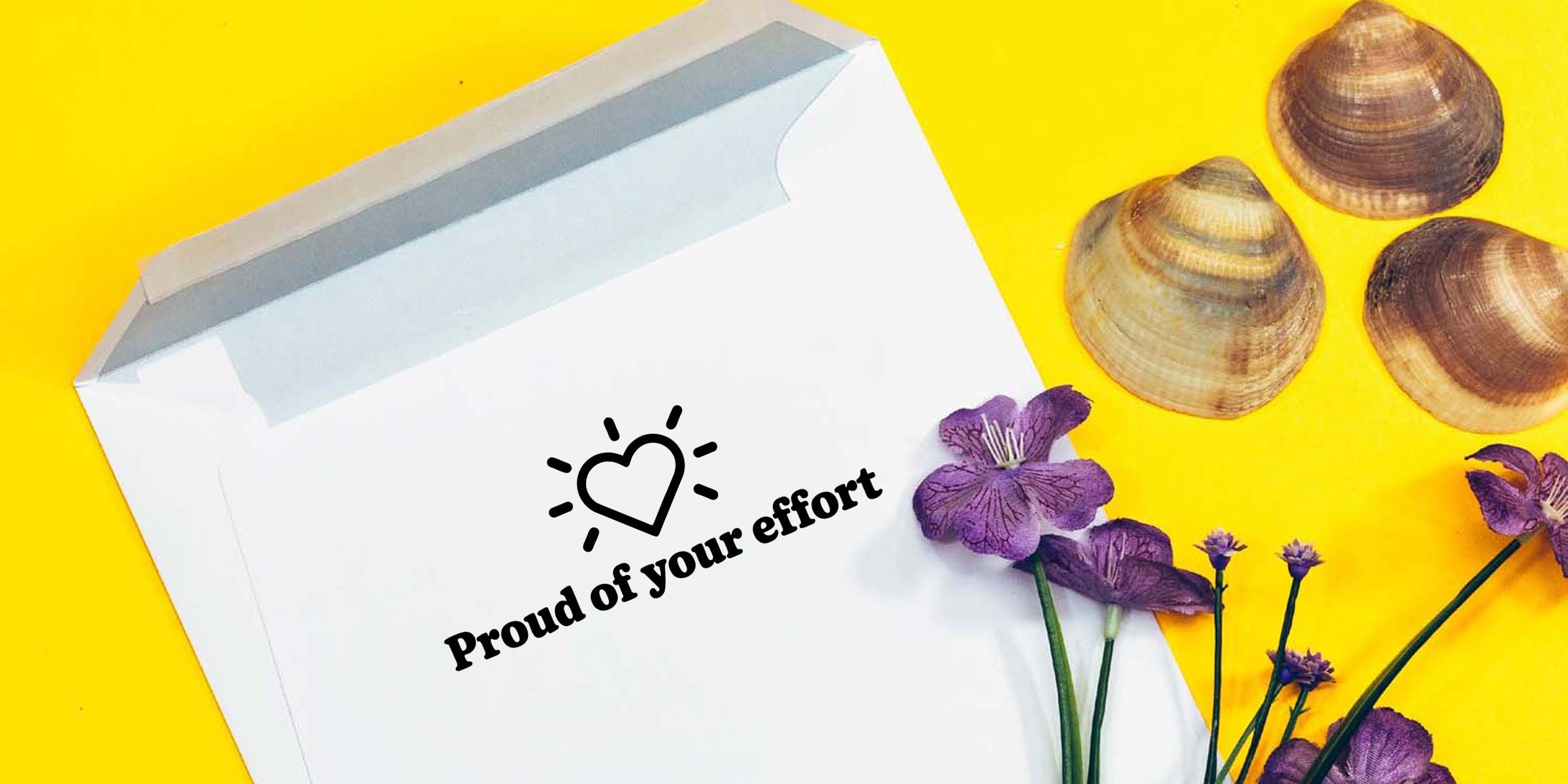 White envelope on a bright yellow background with seashells and purple flowers, printed with a heart icon and the motivational message “Proud of your effort”