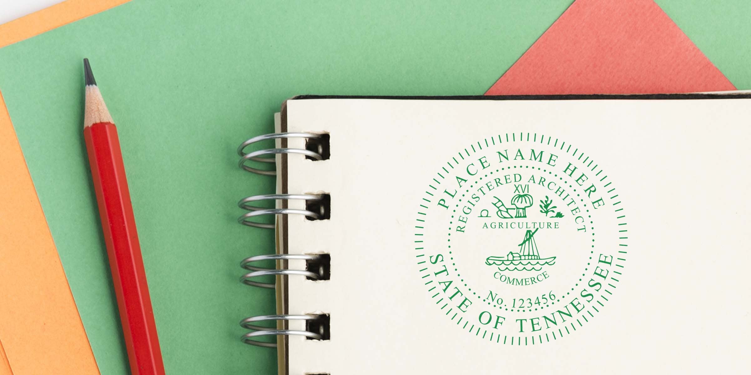 Red pencil next to spiral notebook showing Tennessee architect seal on green and orange paper, highlighting Tennessee architect seal requirements.