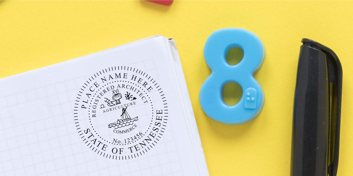 Custom Tennessee architect seal on white paper with blue number 8 and black pen, set against a yellow background, meeting Tennessee architect seal requirements.