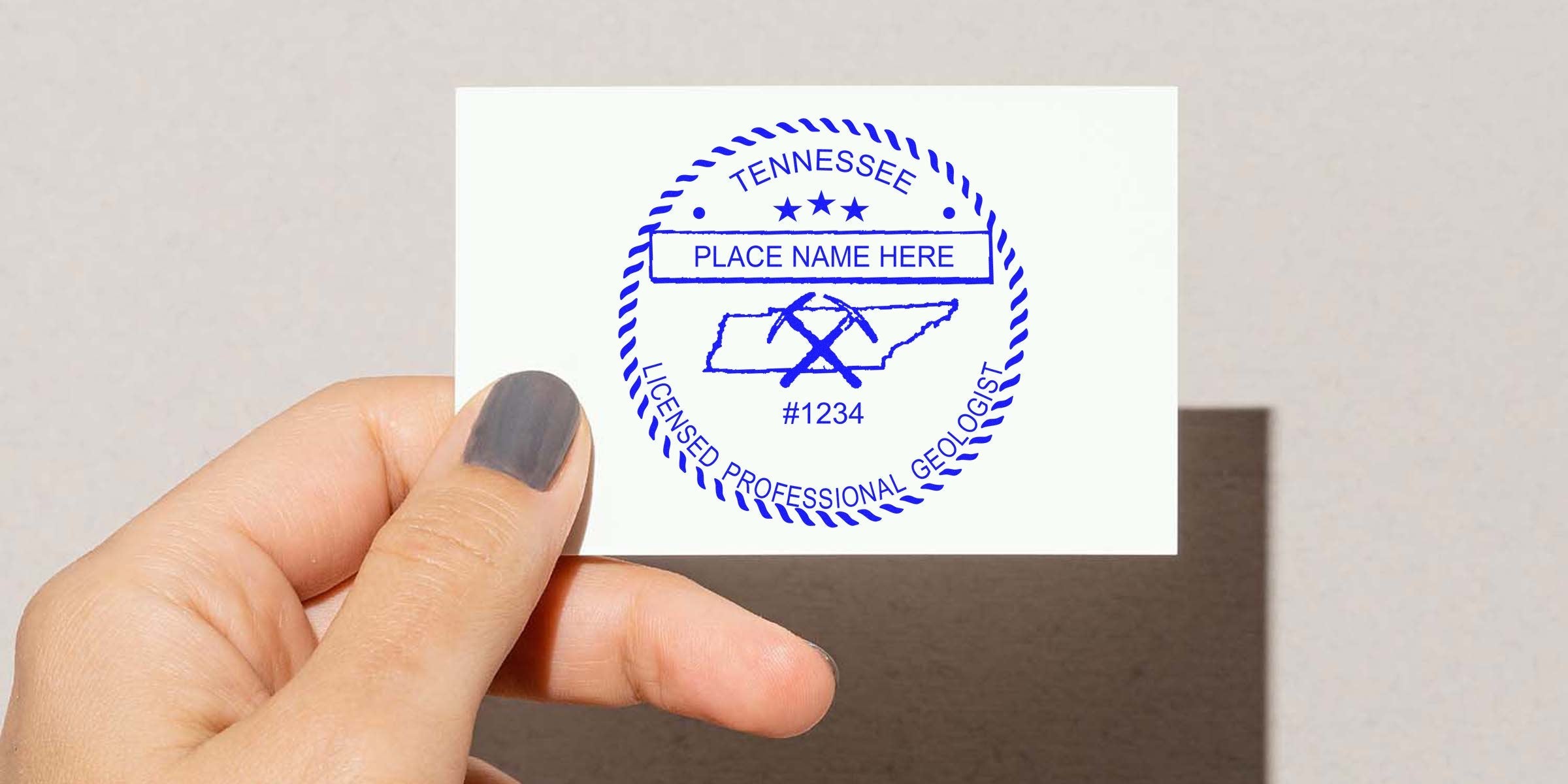 Hand holding white card with Tennessee geologist stamp, showing the stamp application process.