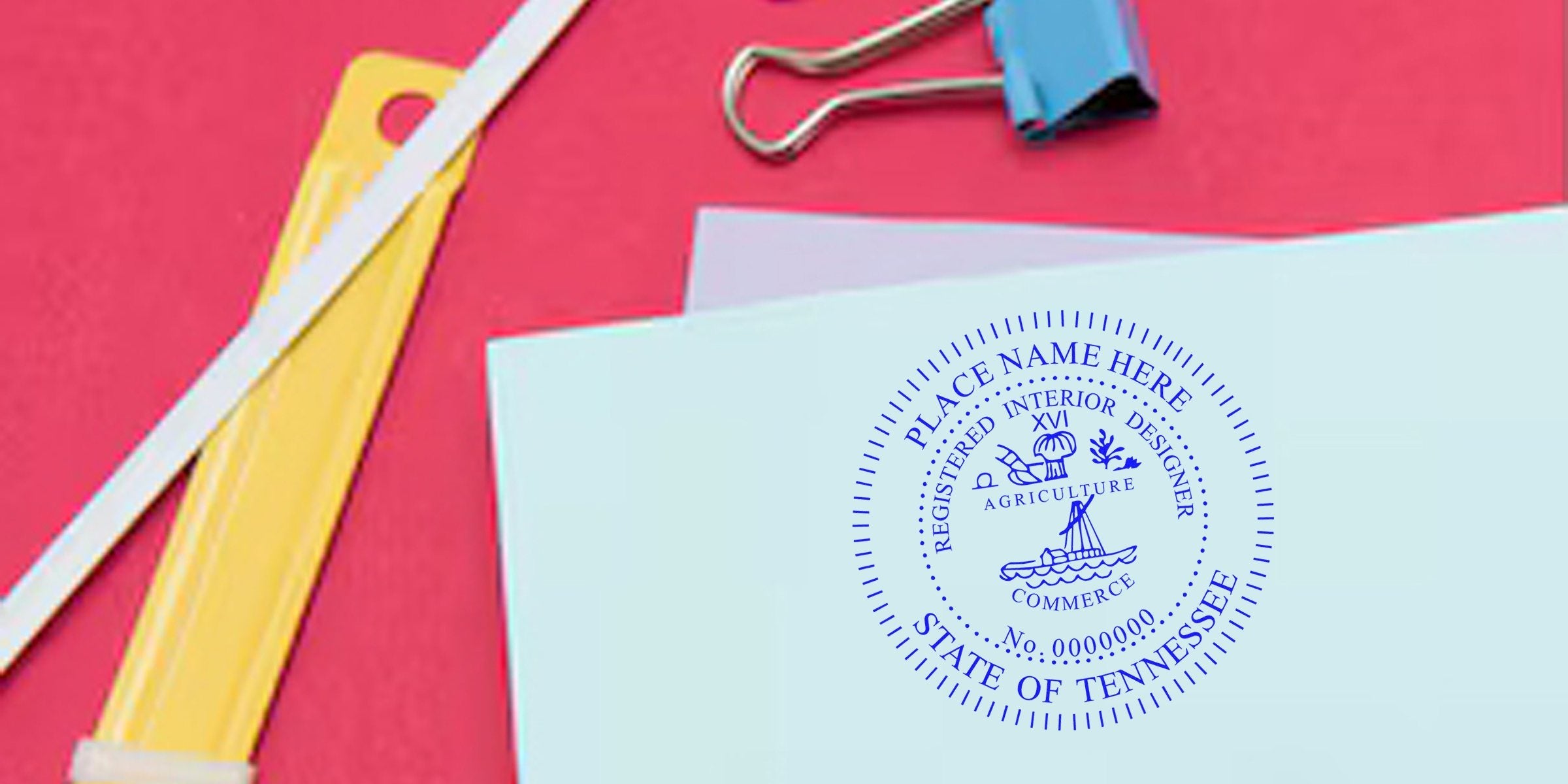 Blue Tennessee interior designer stamp on white paper with yellow letter opener and blue binder clip on red background, symbolizing Tennessee interior design licensing.