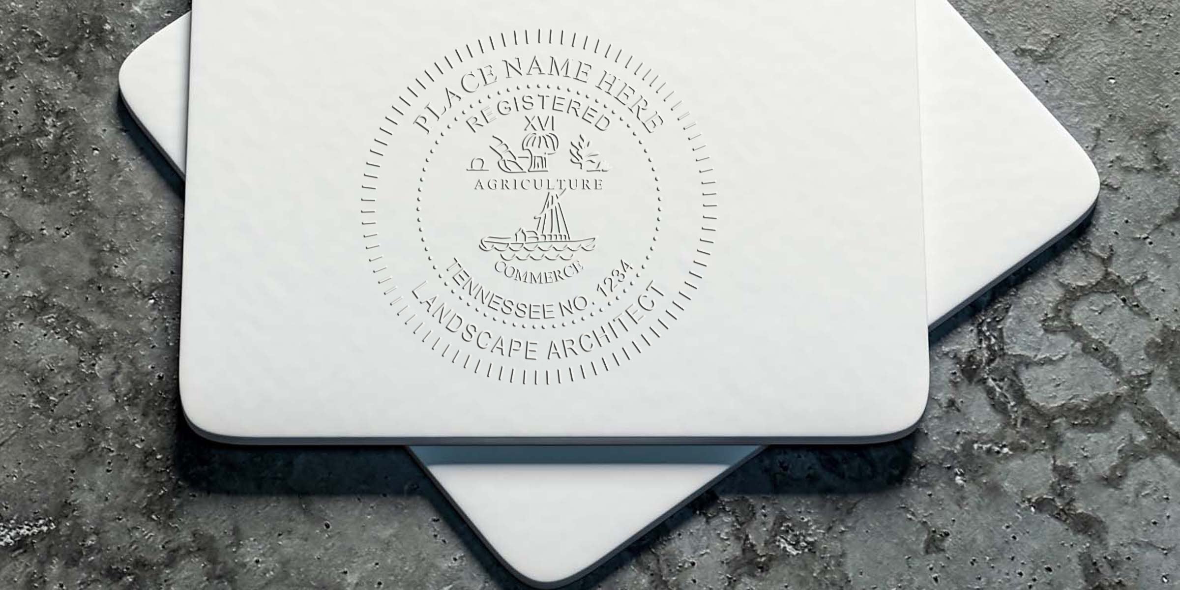 Tennessee landscape architect stamp embossed on white business cards, placed on textured concrete, following Tennessee landscape architect guidelines.