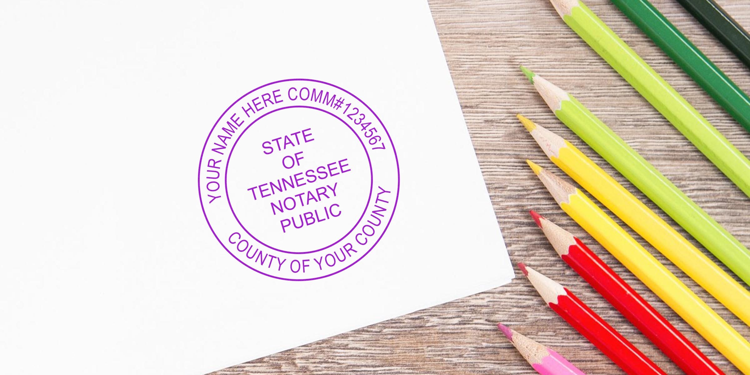 Tennessee notary public stamp on paper with colored pencils on wooden table, displaying Tennessee notary seal size and dimensions.