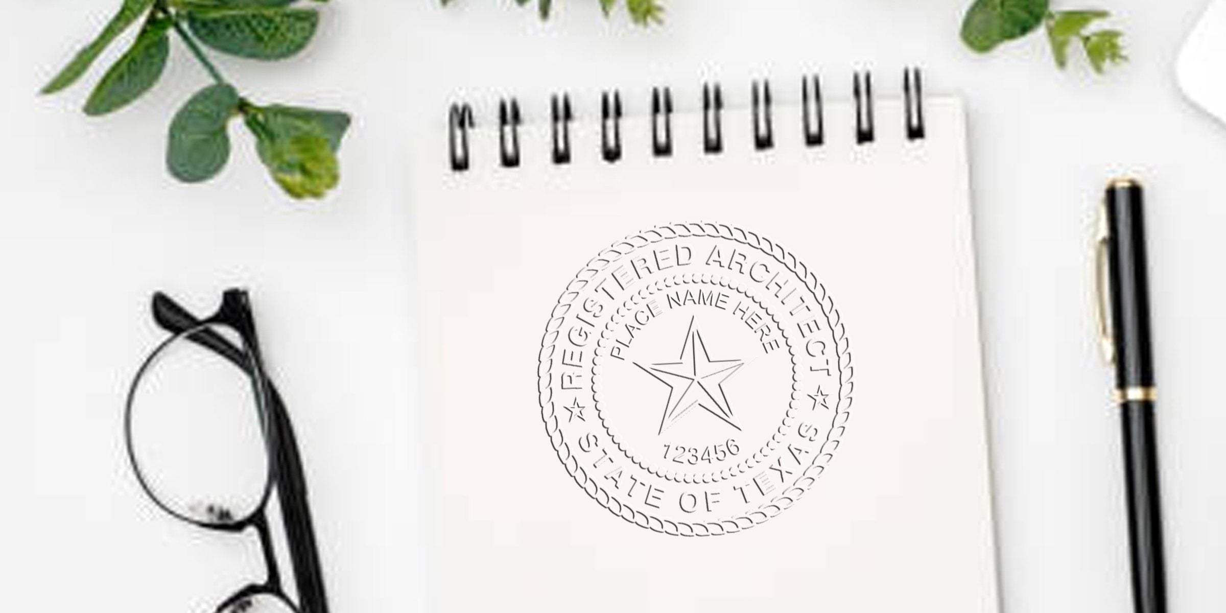 Texas architect seal stamp on white notepad with black pen and glasses, showing architect seal design, surrounded by tools and green leaves background.