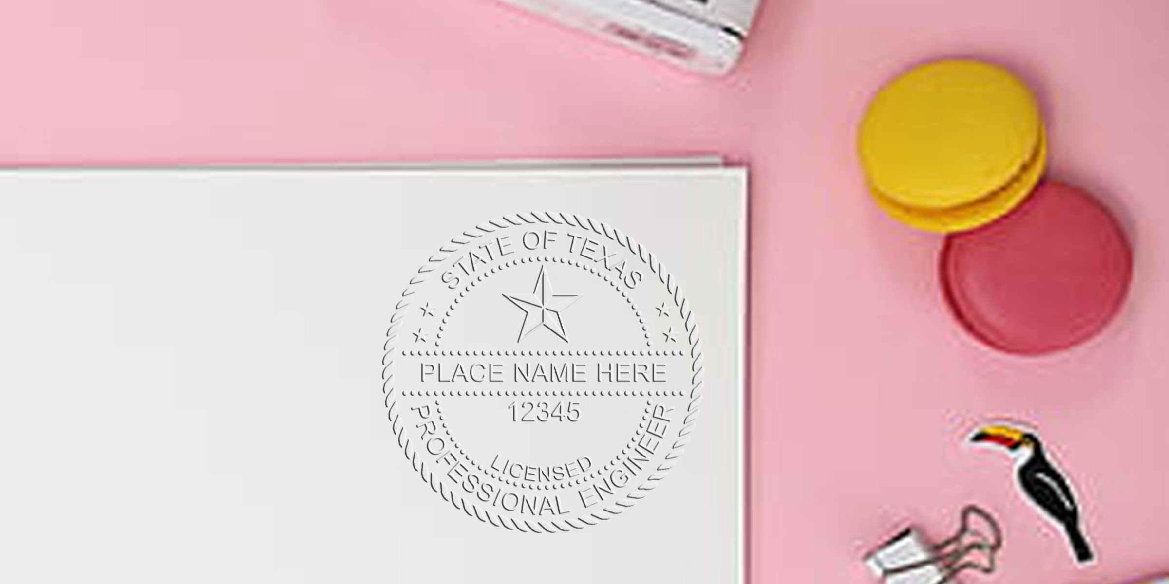 Texas engineering seal embossed on white paper, surrounded by colorful macarons and office supplies on a pink background, highlighting the seal design.