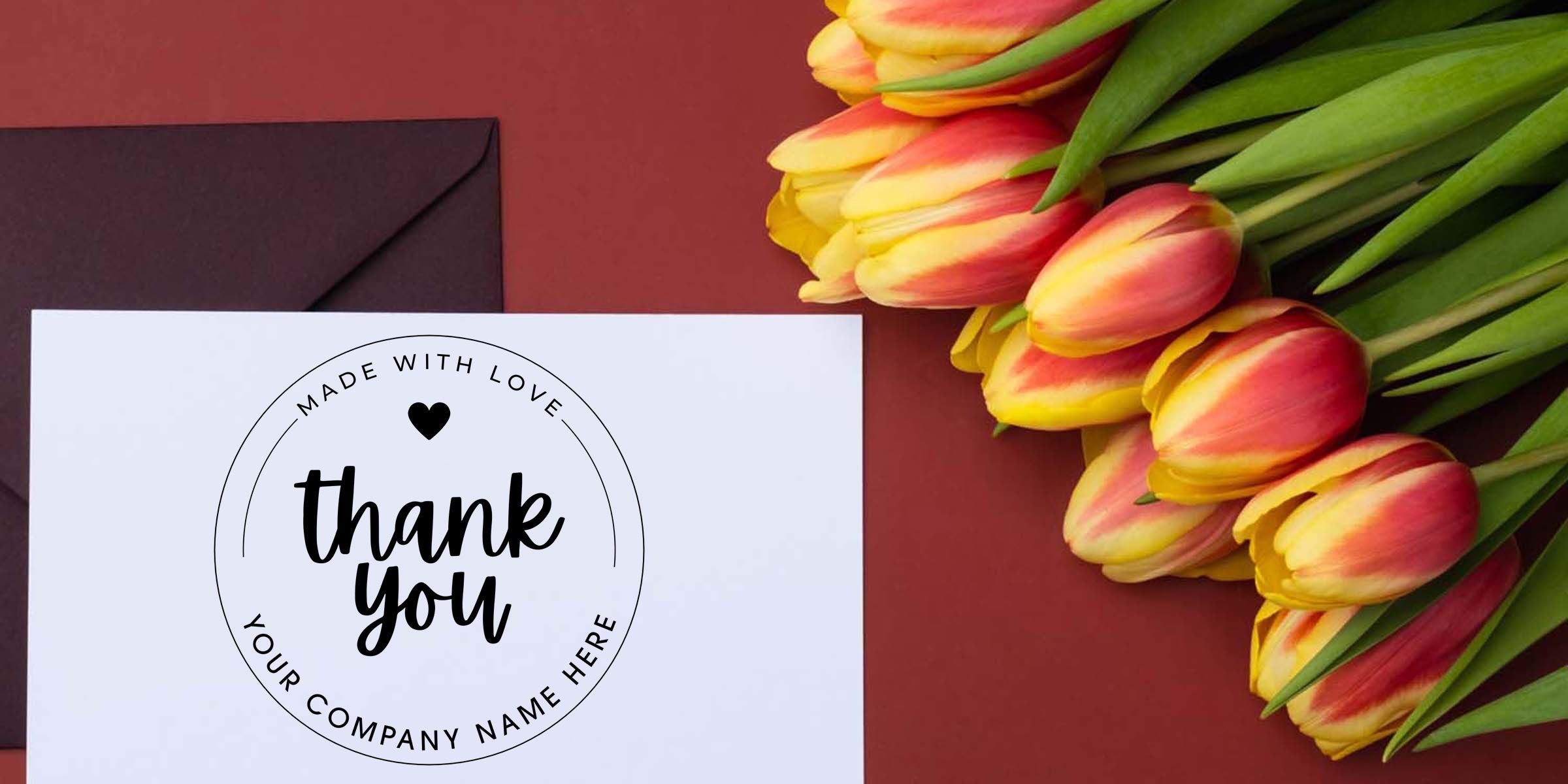Thank you card with custom logo, black envelope, and bouquet of red and yellow tulips on a burgundy background