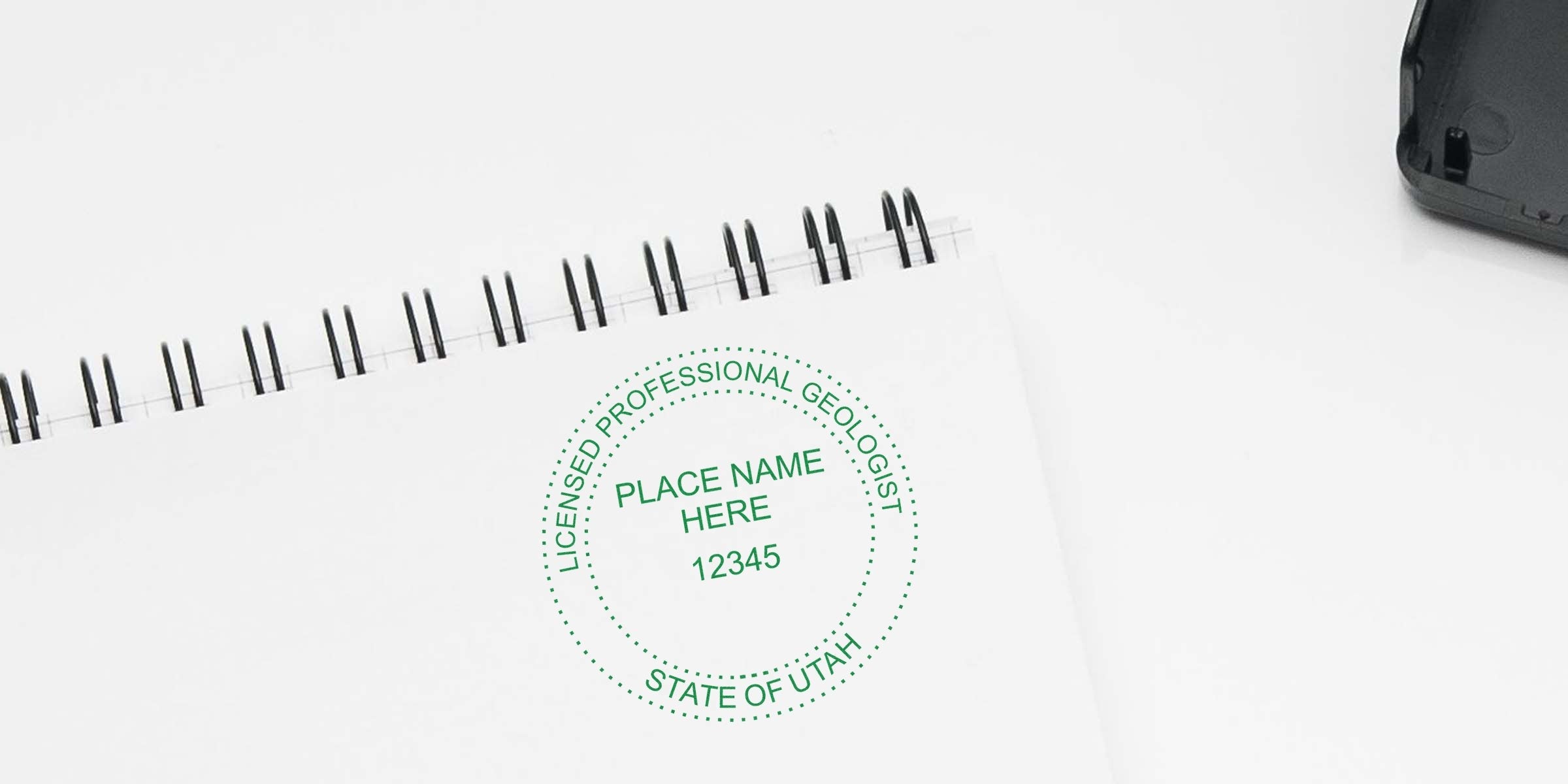 Custom geologist stamp with Utah geologist seal on white spiral notebook.