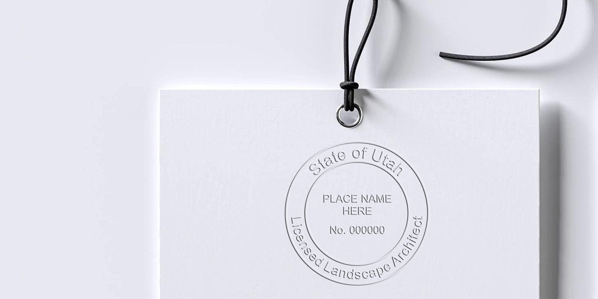 Utah landscape architect stamp embossed on white tag with black string, symbolizing Utah landscape architect licensing.