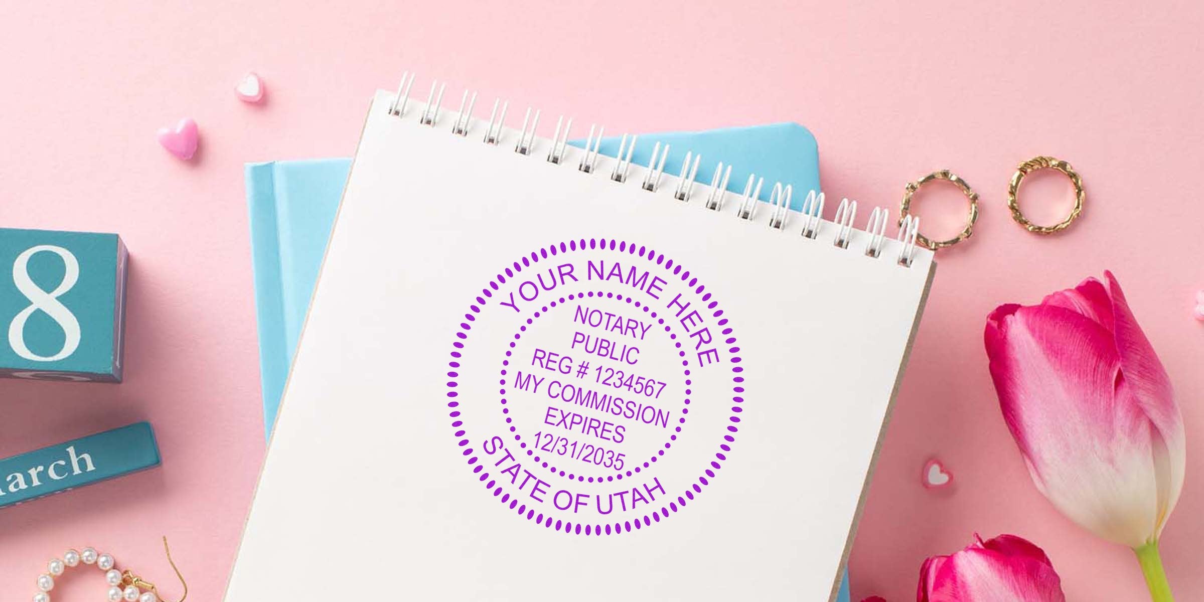 Utah notary seal stamp on a notebook next to pink tulips and a March calendar block, showcasing the Utah notary commission seal design from the notary public seal guide.