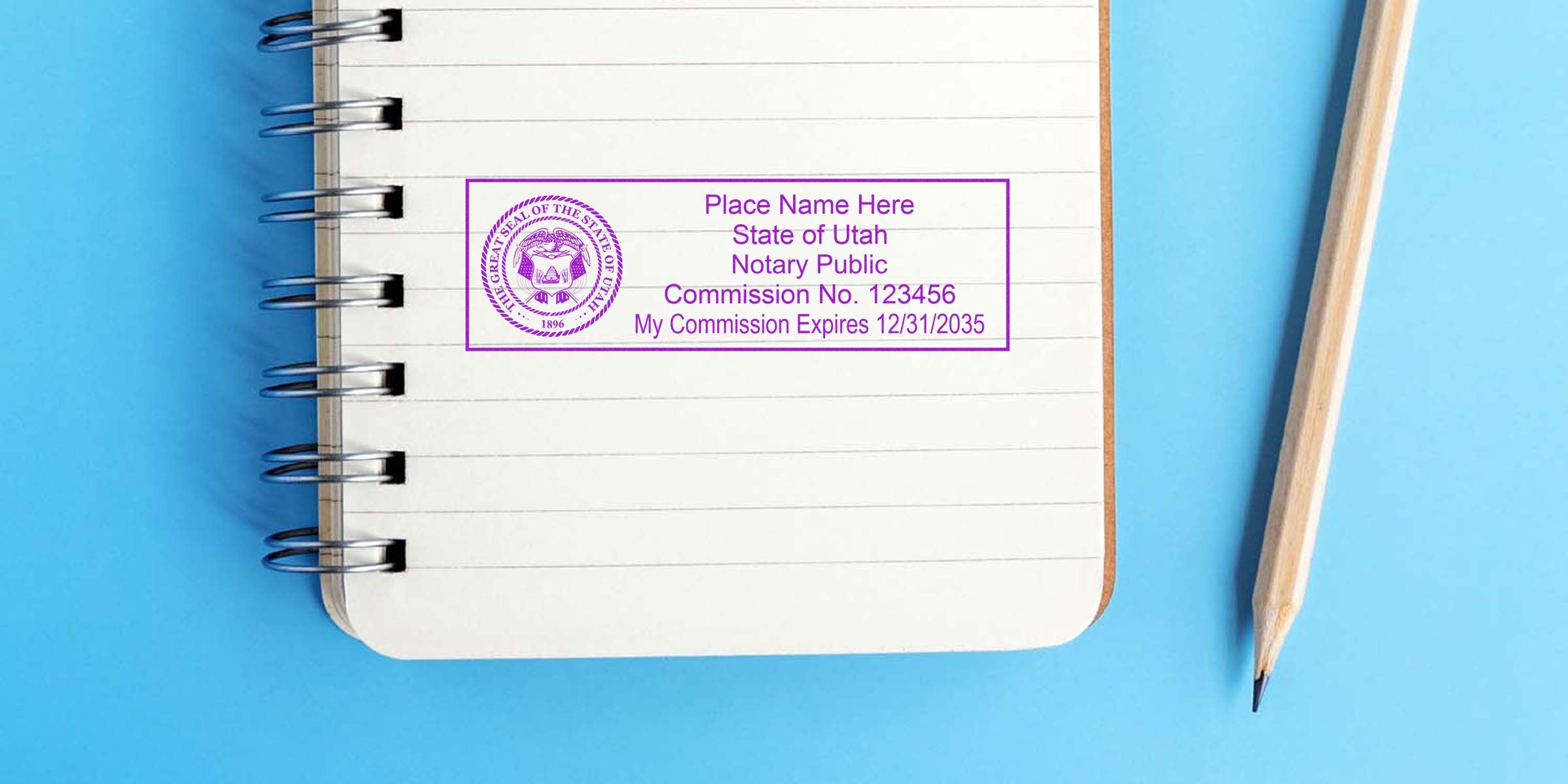 Utah notary public stamp on notebook with pencil on blue background, showcasing affordable Utah notary supplies and products.