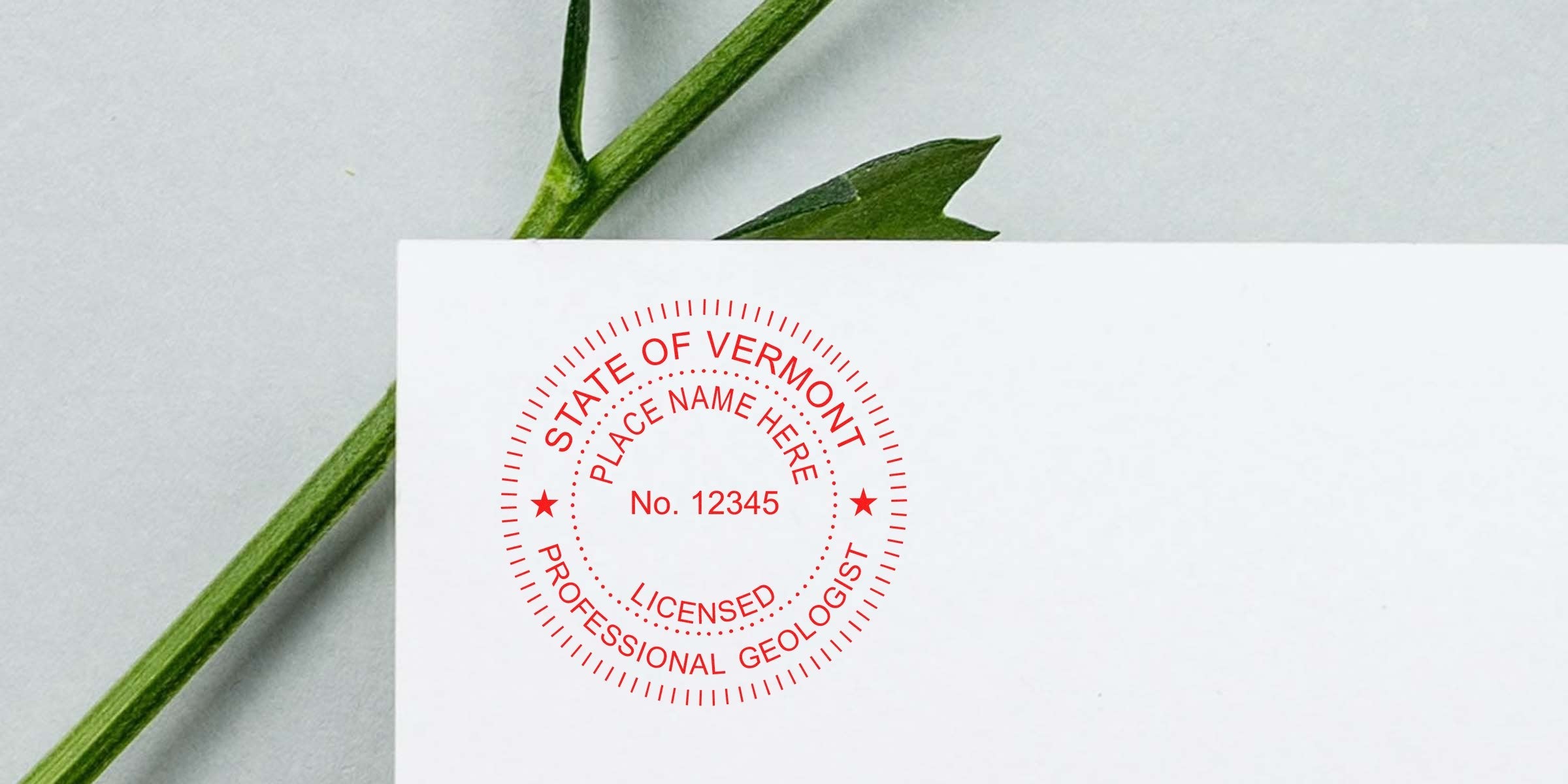 Red Vermont geologist license stamp on white paper with green plant stem background, showing geologist stamp requirements.