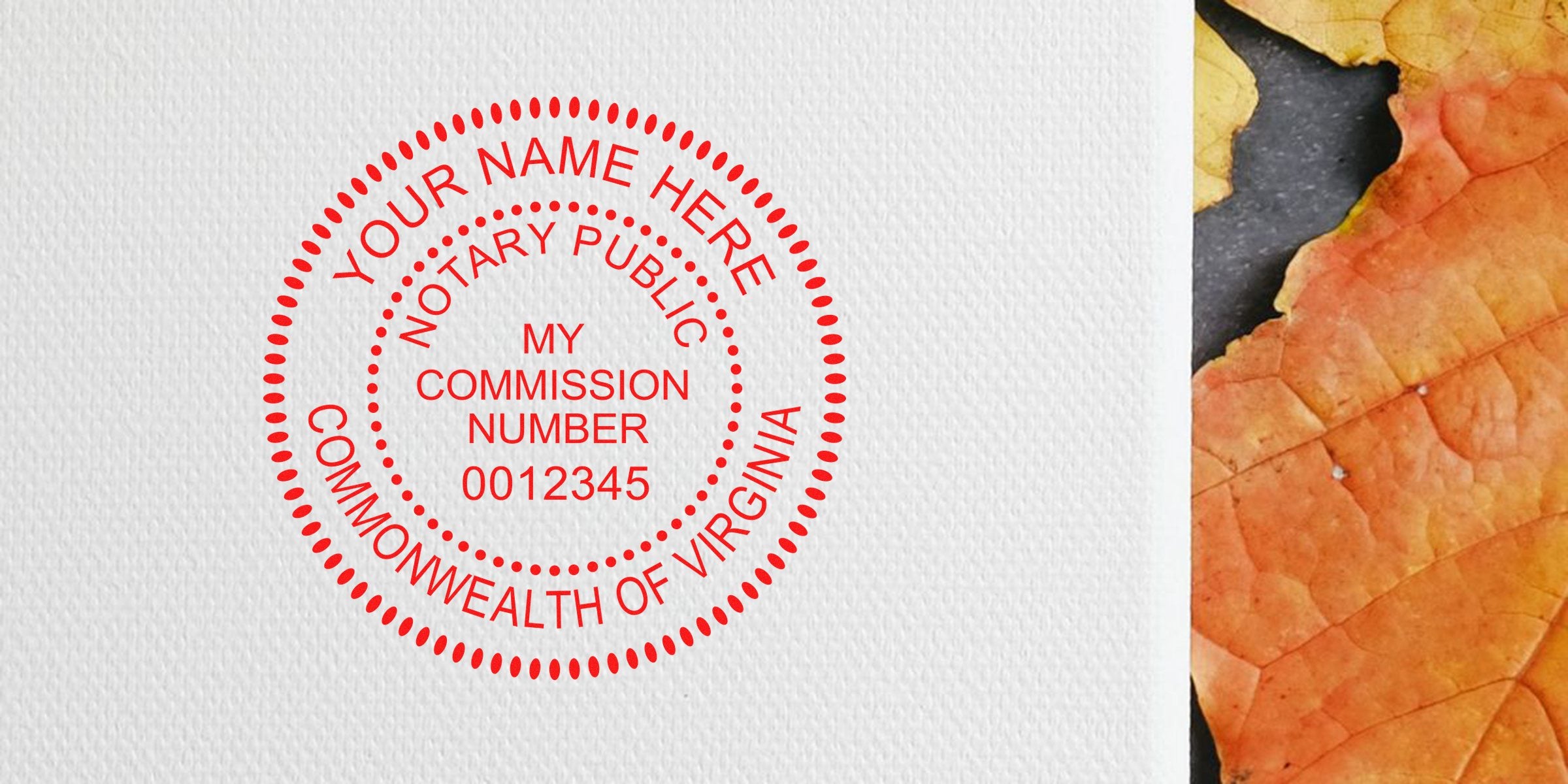 Virginia notary round self-inking stamp with commission number on textured paper next to an autumn leaf.
