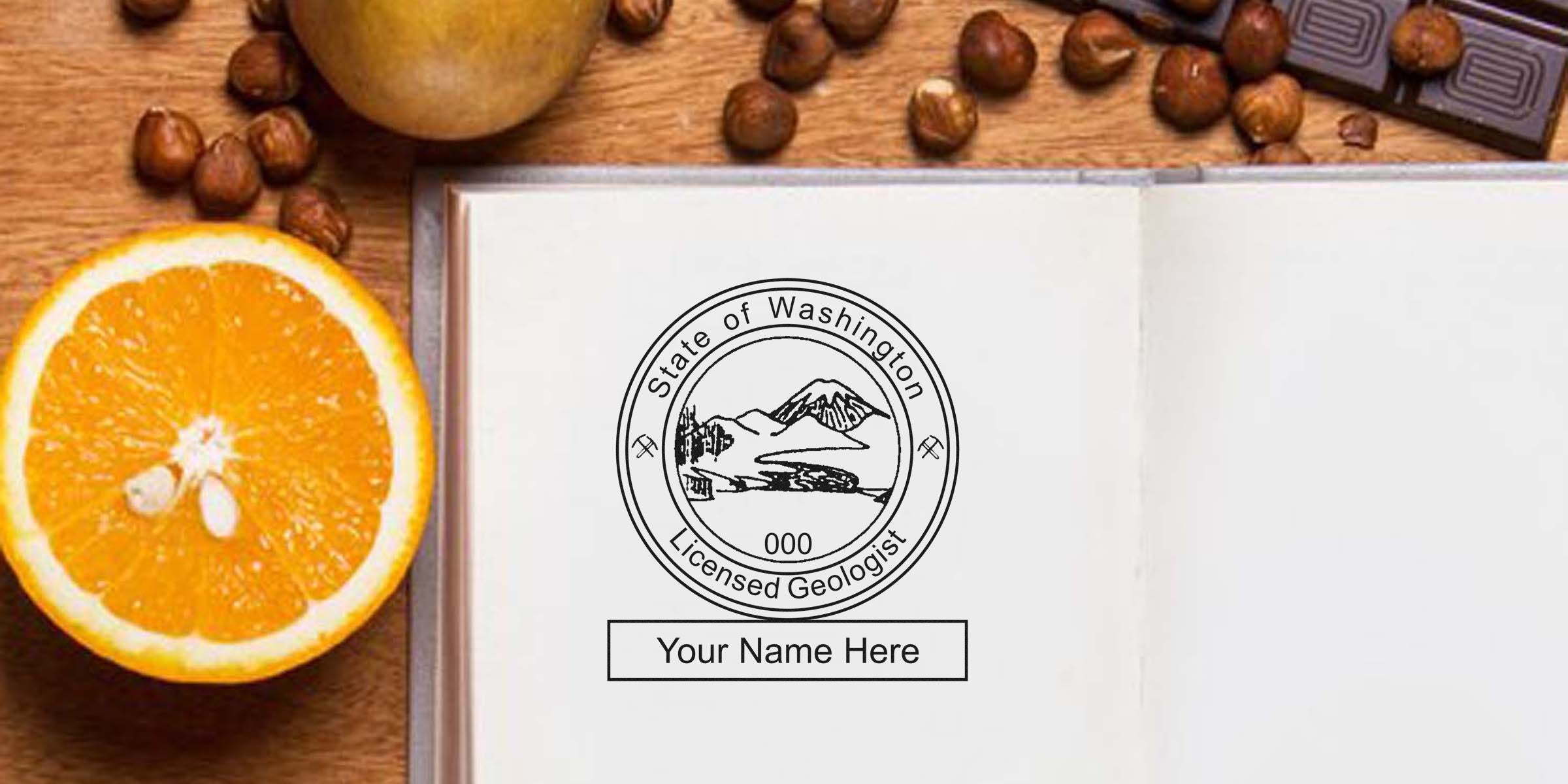 Washington geologist stamp embossed on open notebook next to orange slice and hazelnuts on wooden table, meeting embossing requirements.