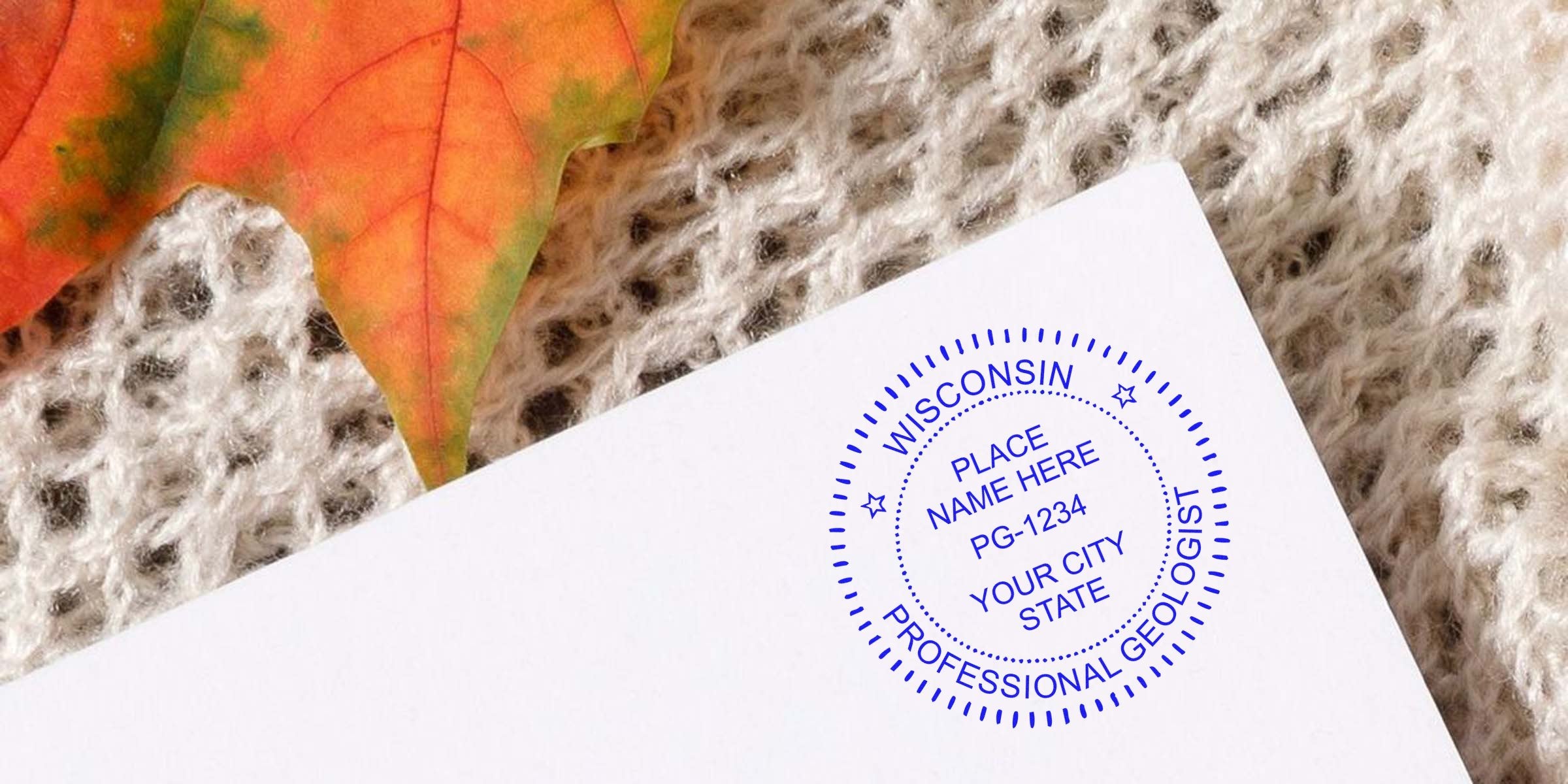 Wisconsin geologist's professional stamp on white paper, set against autumn leaves and knitted fabric, unveiling seal design secrets.