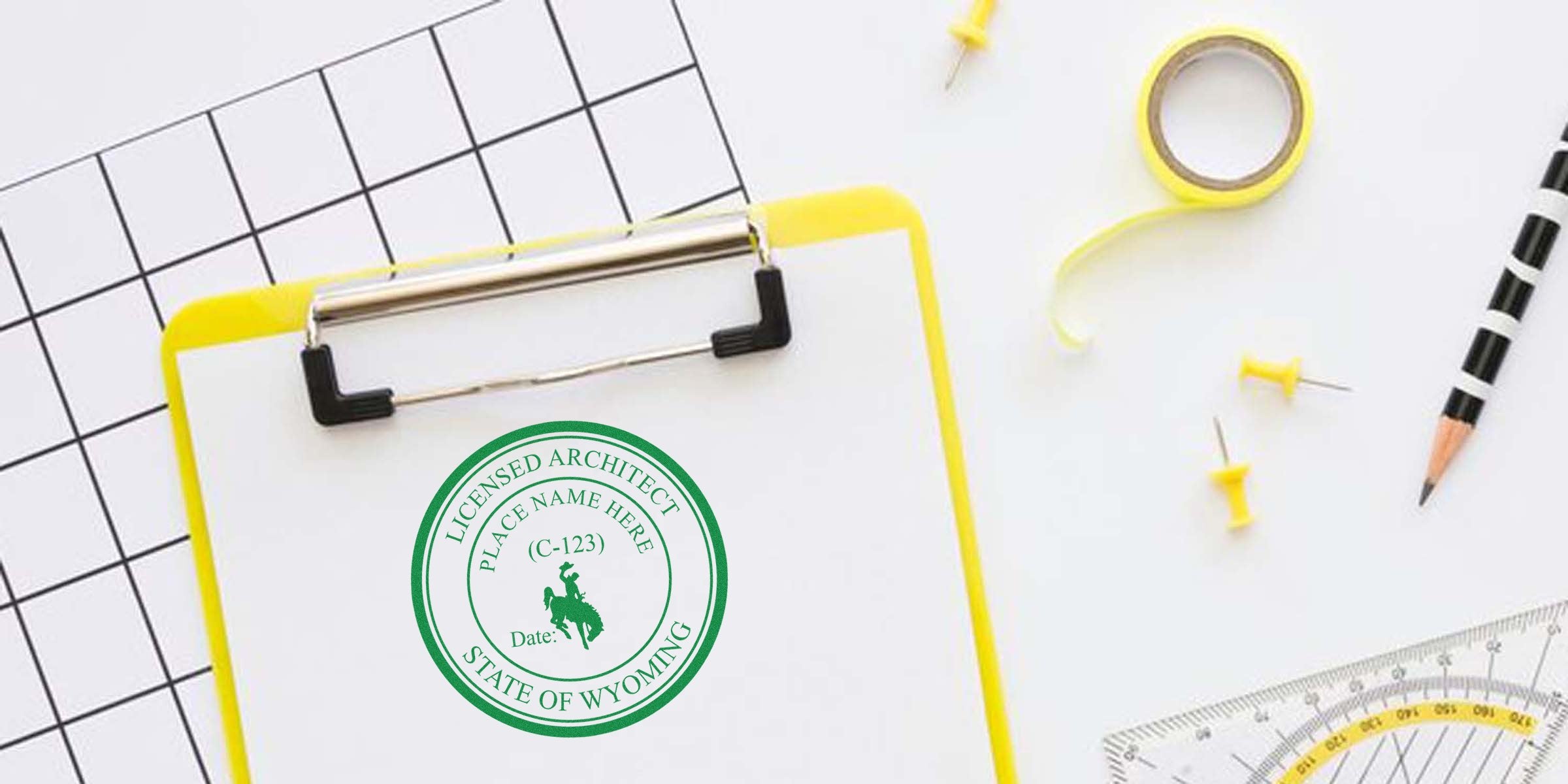 Wyoming architect stamp on clipboard with office supplies and drafting tools, showcasing a Wyoming architect stamp buying guide.