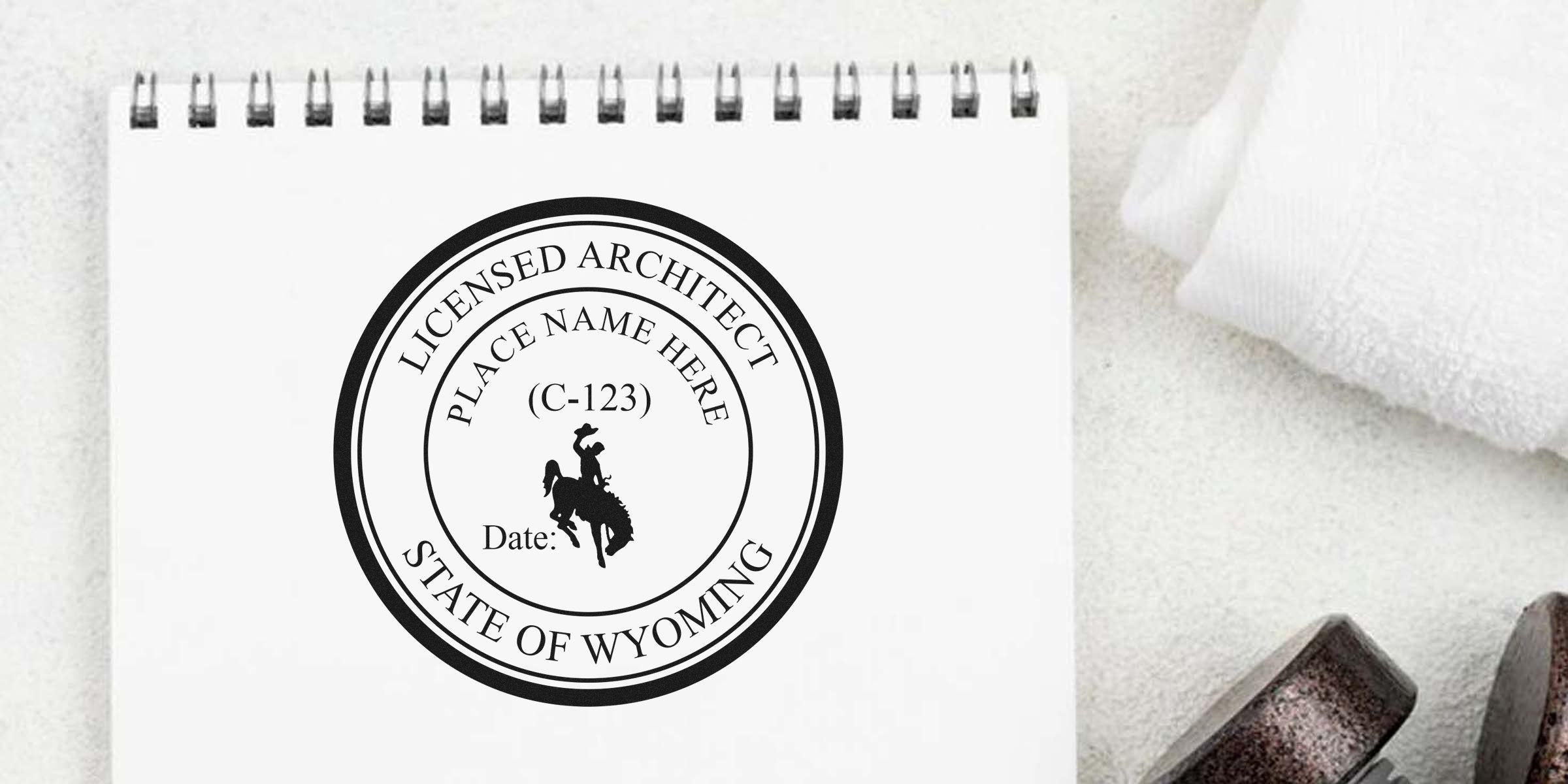 Wyoming architect stamp on white notepad with cowboy logo and certification date, representing Wyoming licensed architect seal and online certification.