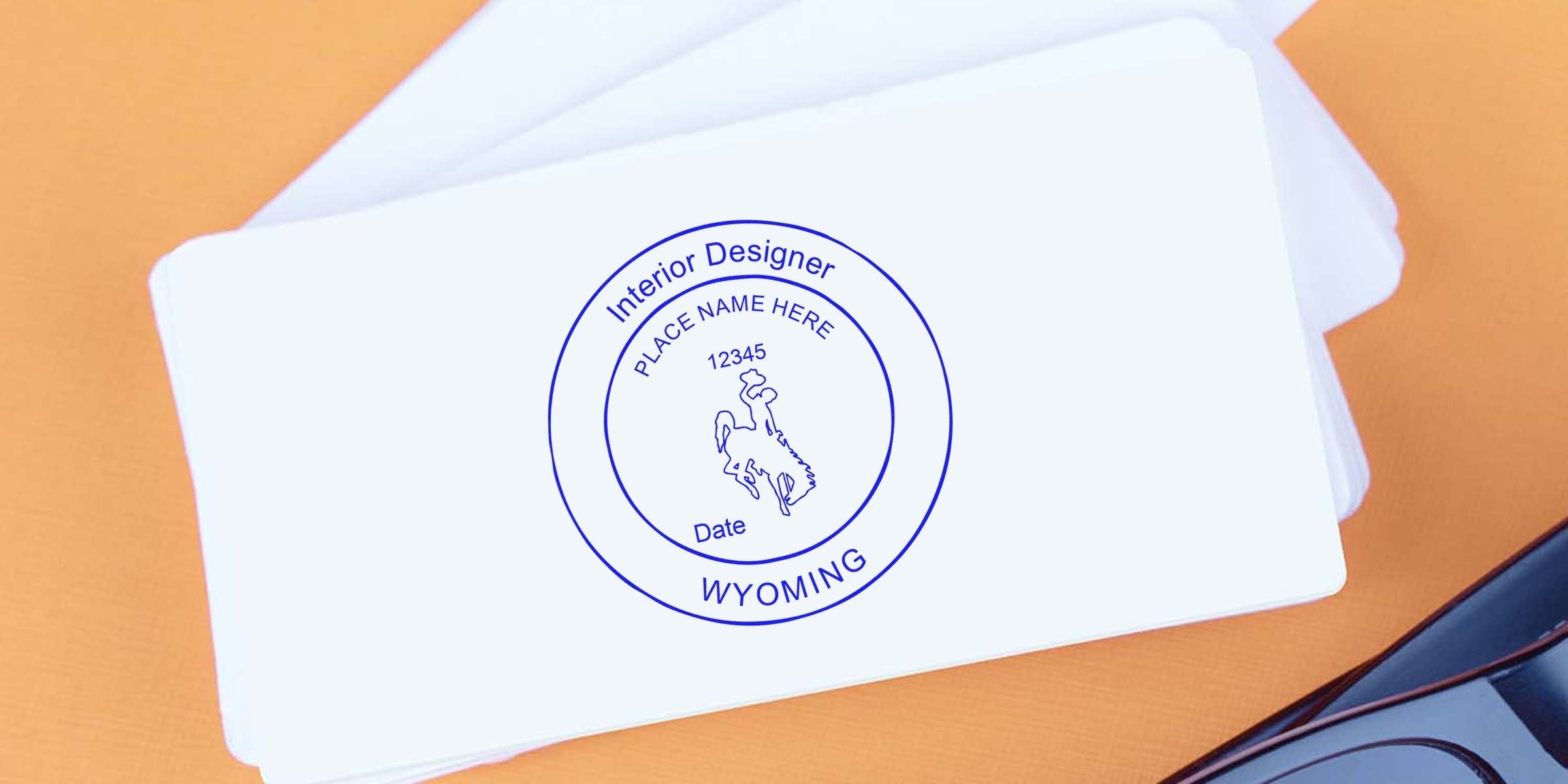 Wyoming interior designer stamp on white cards with cowboy logo, customizable text, plus details on Wyoming interior designer and stamp renewal process.