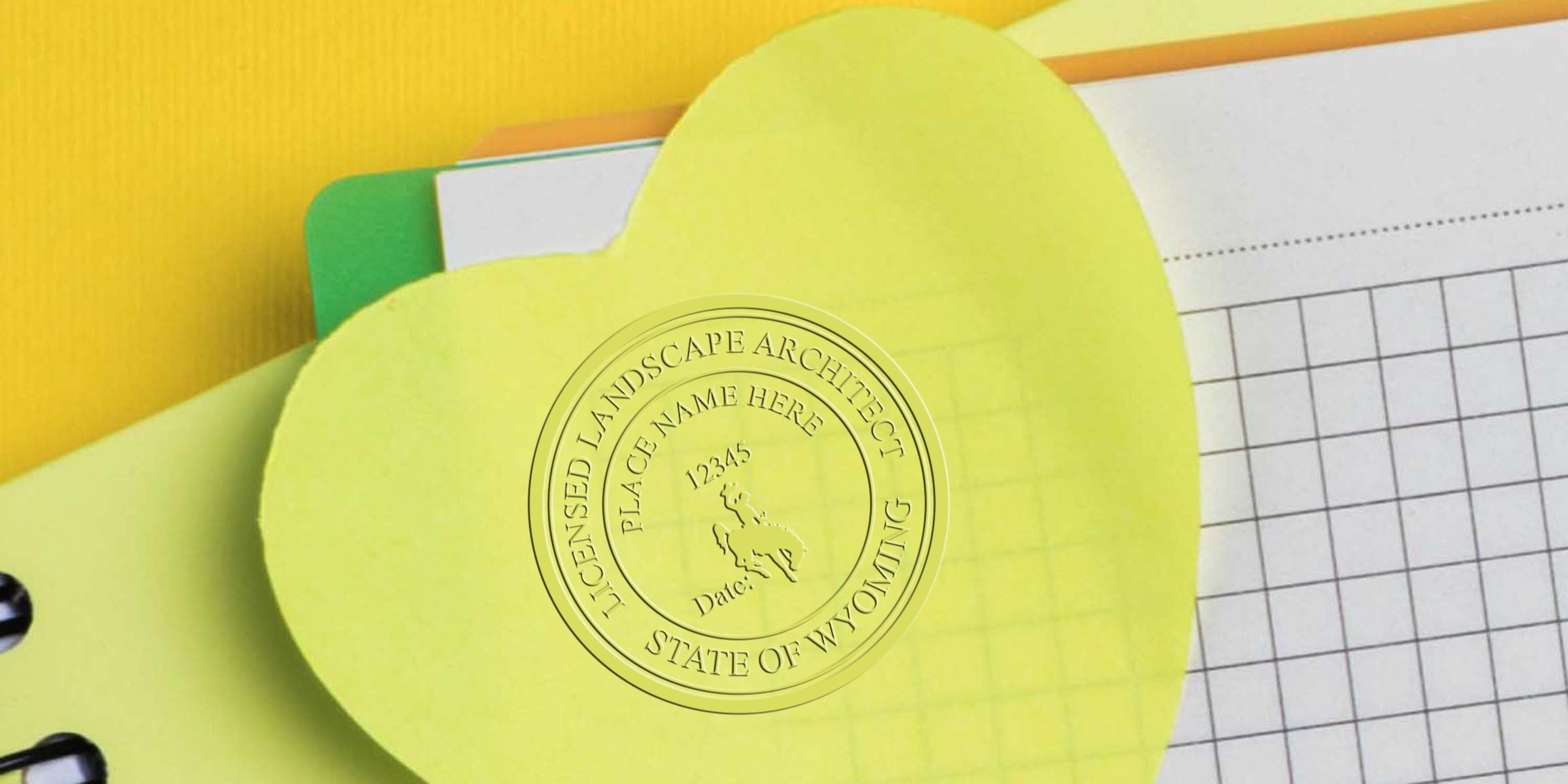 Yellow heart-shaped sticky note with Wyoming landscape architect stamp and licensed landscape architect Wyoming seal on office supplies.