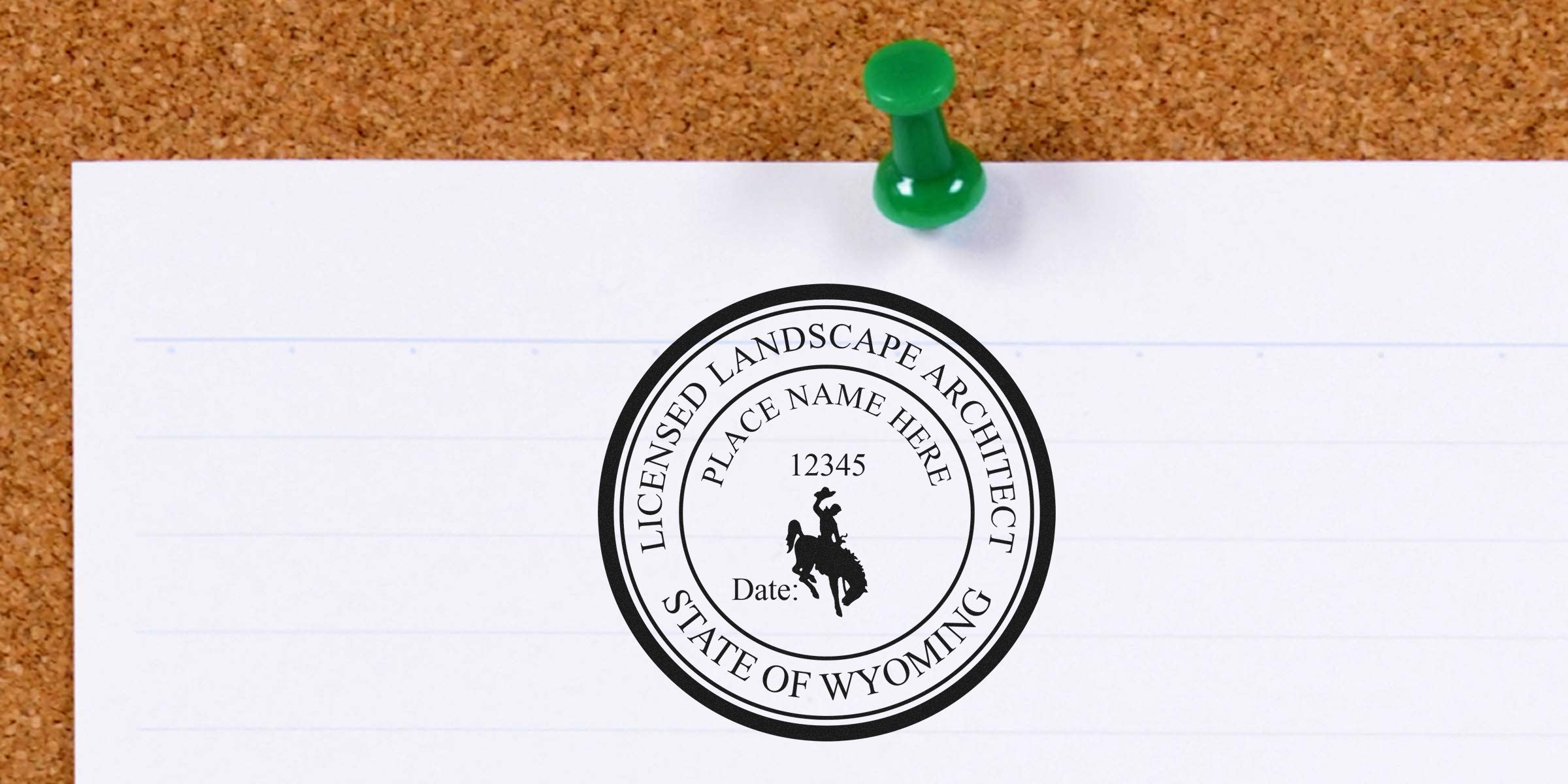 Wyoming landscape architect stamp with a custom cowboy logo pinned on a corkboard.