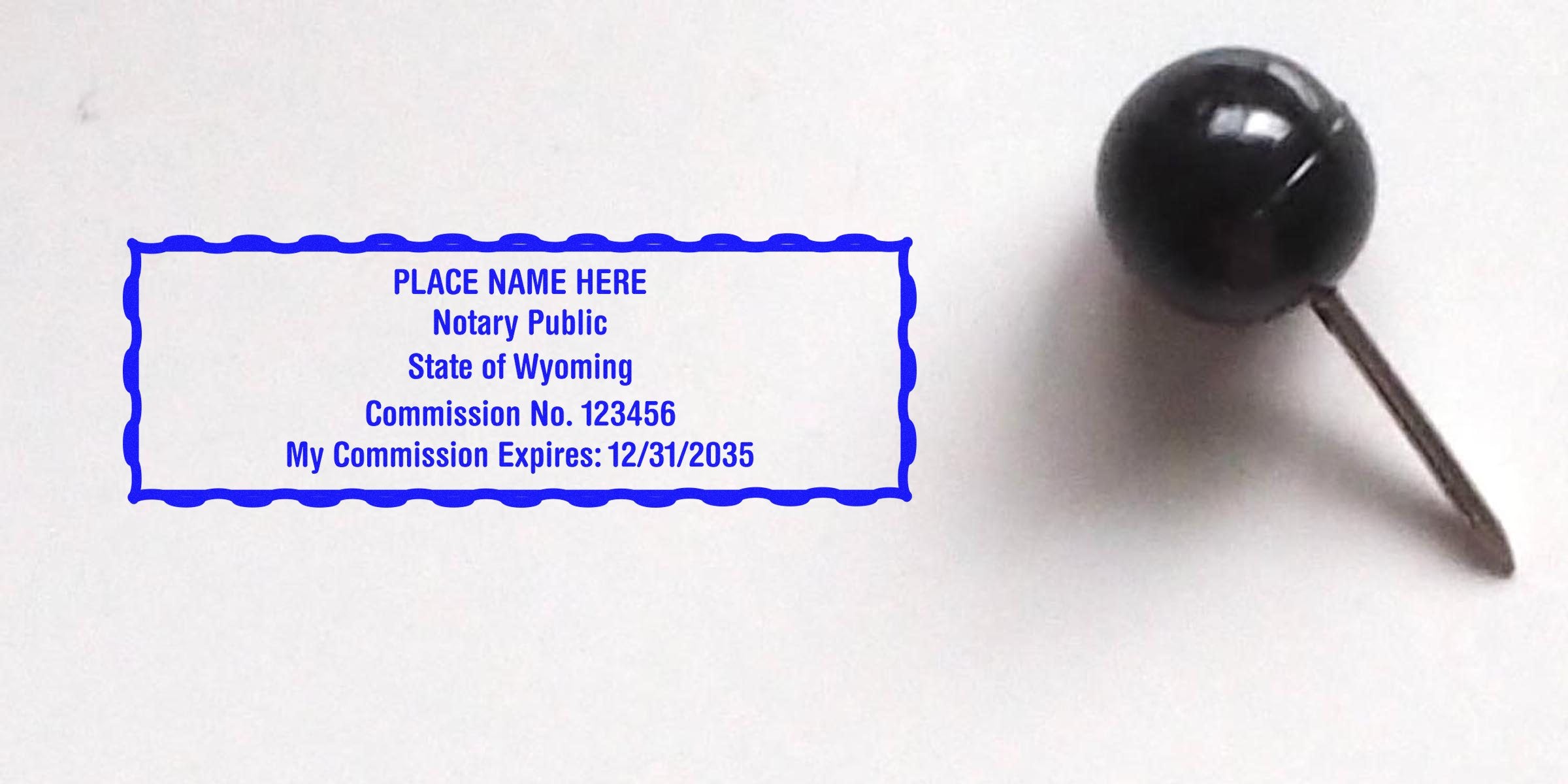 WY Notary Seal with Wyoming notary stamp, commission number, and expiration date next to a black push pin on white, highlighting Notary Practice Essentials.