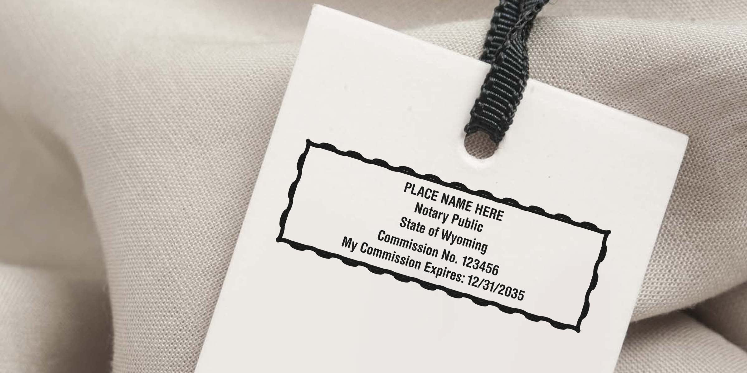 Wyoming notary public commission certificate tag with Wyoming notary seal and seal expiration date on fabric background.