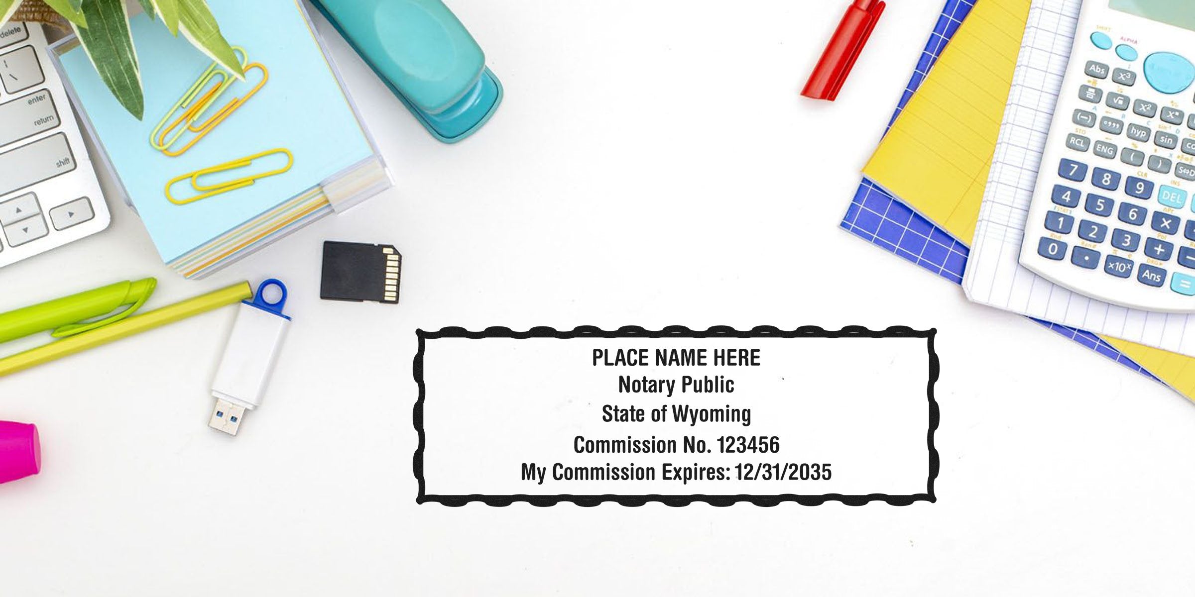 Wyoming notary stamp with commission number next to calculator, USB drive, paper clips, and pens on white desk, showing a notary seal guide.