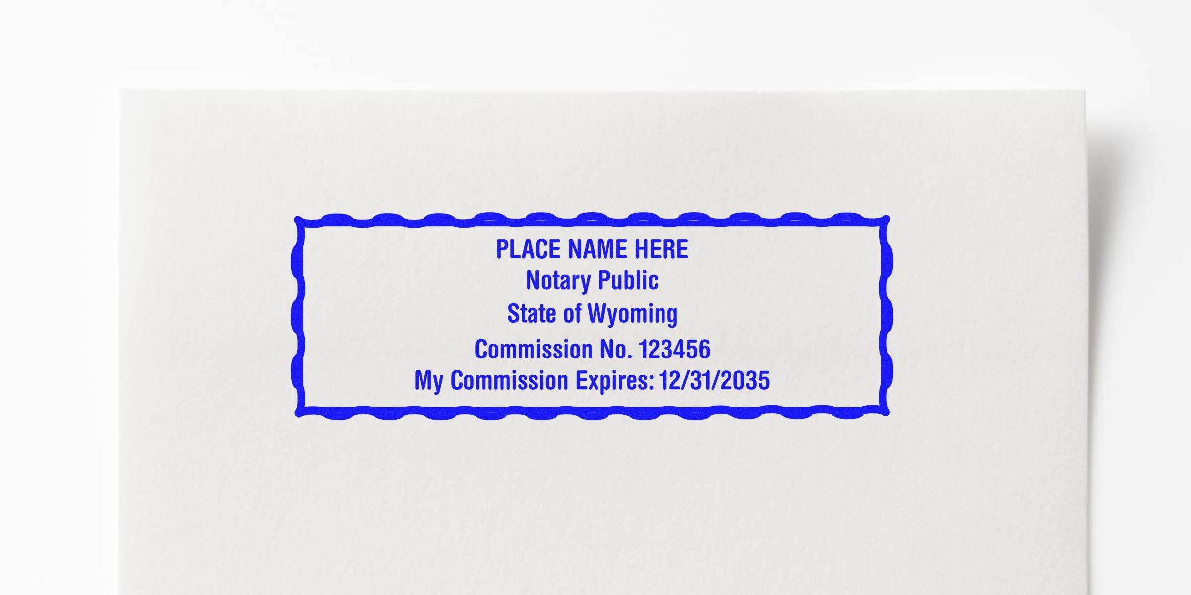 Wyoming custom notary seal stamp with commission number and expiration date on white paper, compliant with Wyoming notary seal requirements.