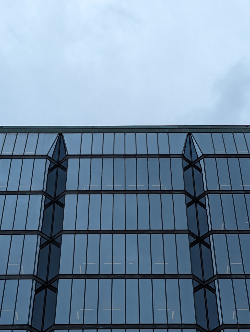 Modern office with reflective glass under blue sky, symbolizing Professional Engineer Seals and compliance with Canadian Engineering Regulations.