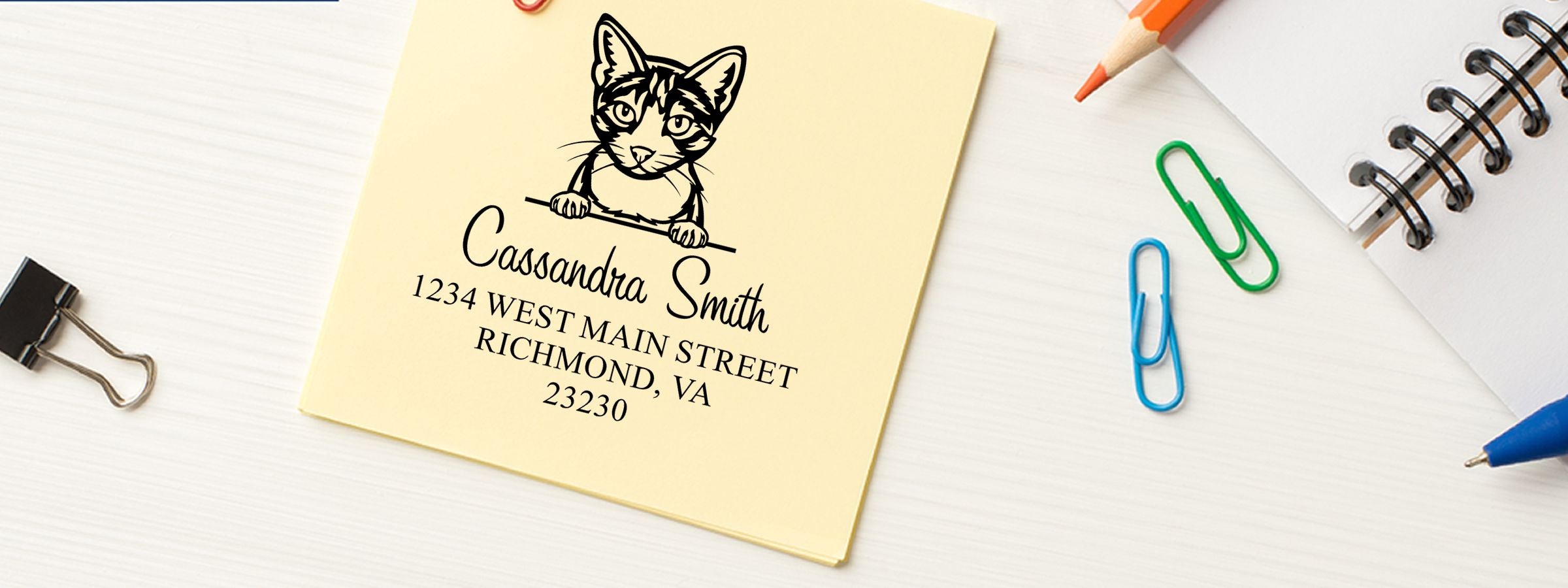 Yellow notepad envelope with cat illustration, Cassandra Smith address, and Aegean Cat Stamps and Custom Seals on a white desk.